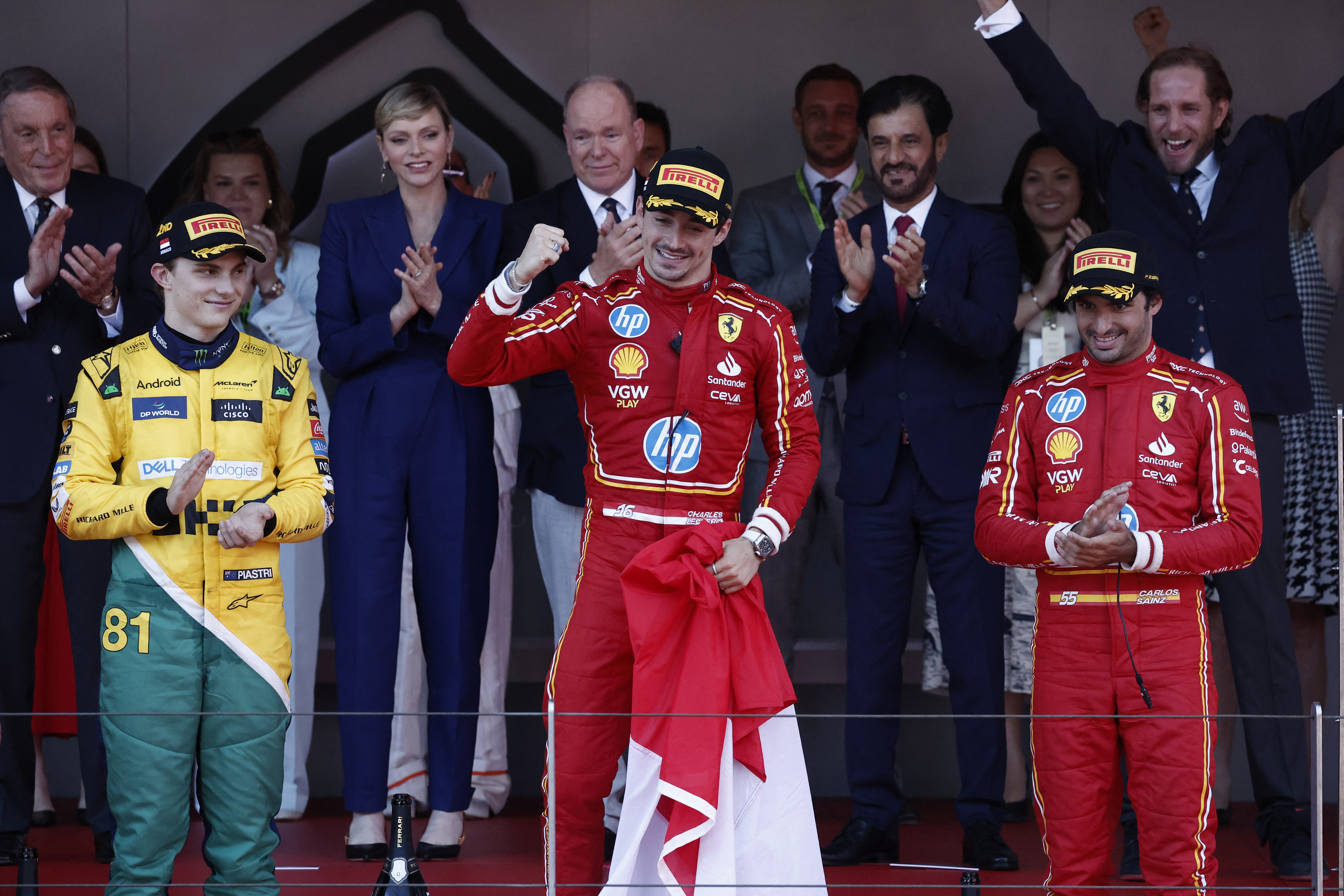 F1 drivers stand on podium.