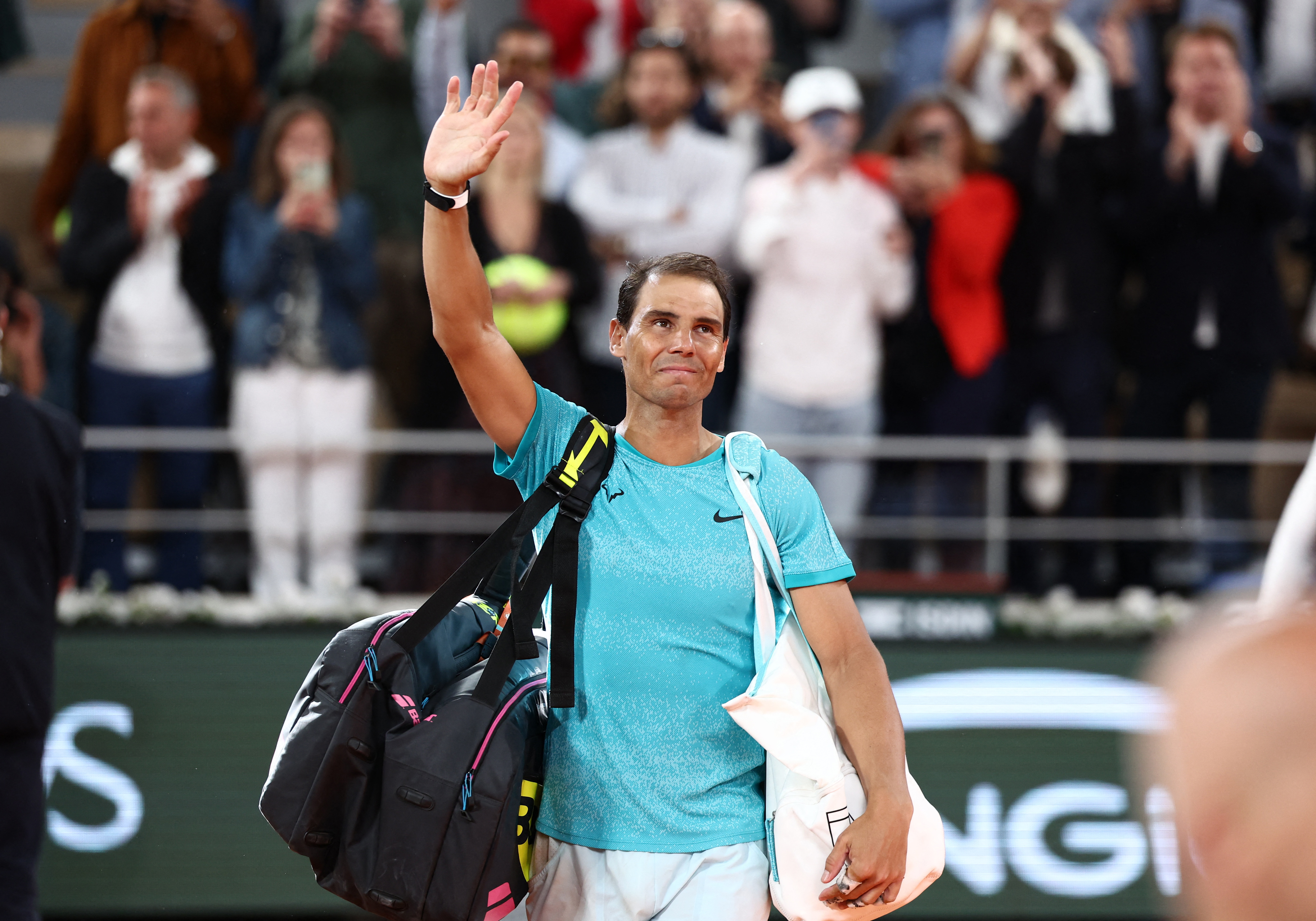 Tennis player waves to crowd.