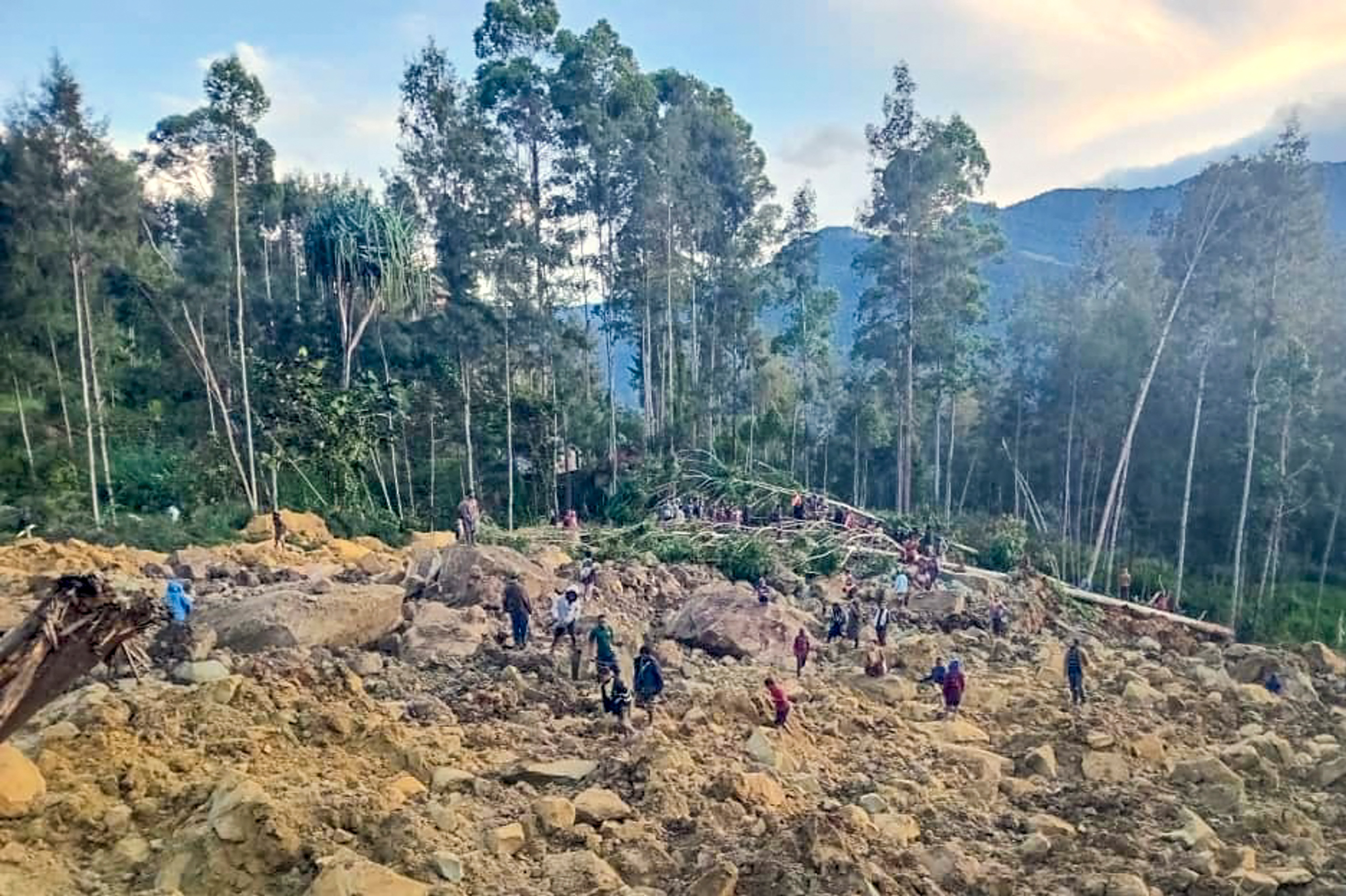 TOPSHOT - People gather at the site of a landslide in Maip Mulitaka in Papua New Guinea's Enga Province on May 24, 2024. Local officials and aid groups said a massive landslide struck a village in Papua New Guinea's highlands on May 24, with many feared dead.(Photo by AFP) RELATED CONTEN