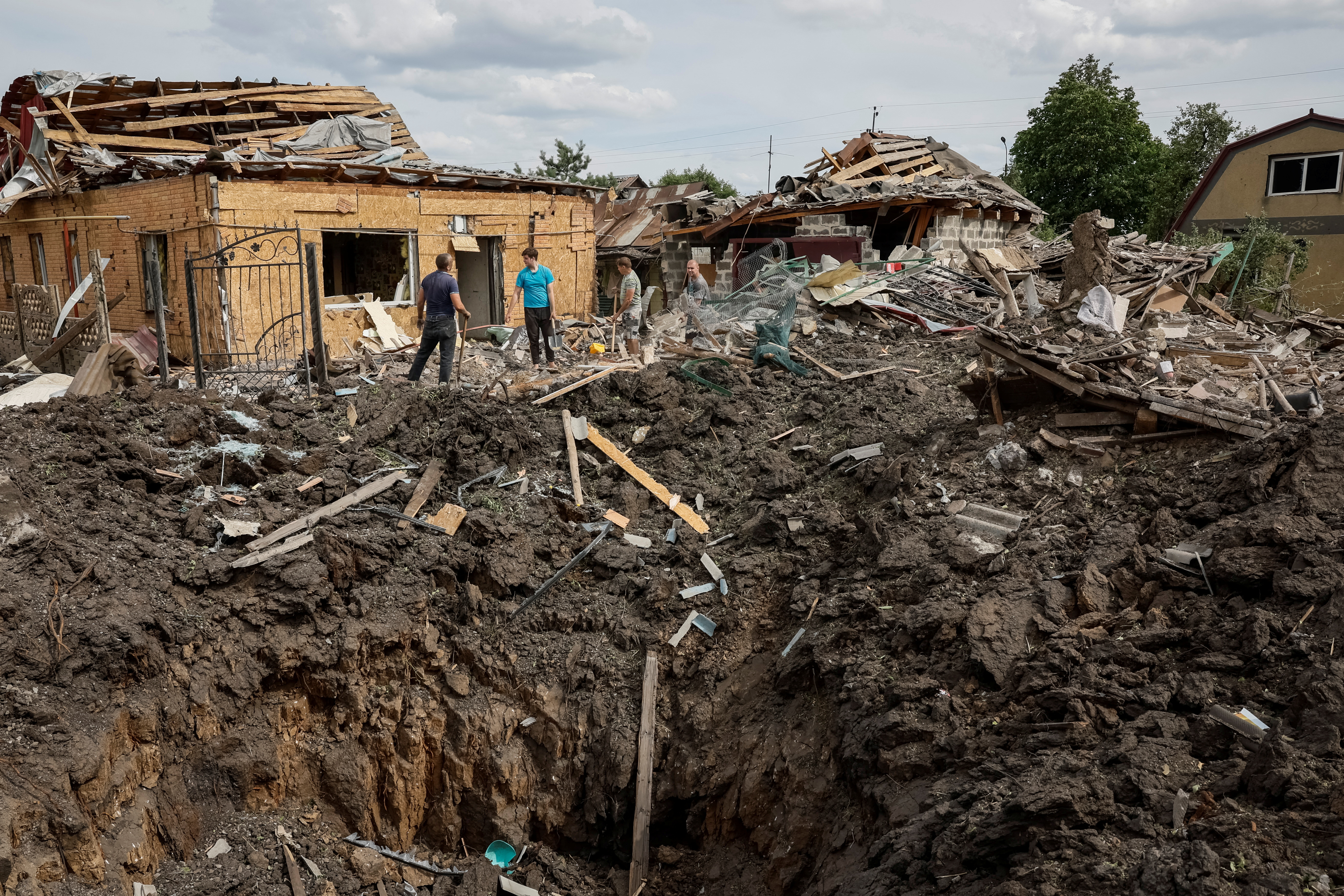 A bomb crater surrounded by destroyed houses in Pokrovsk