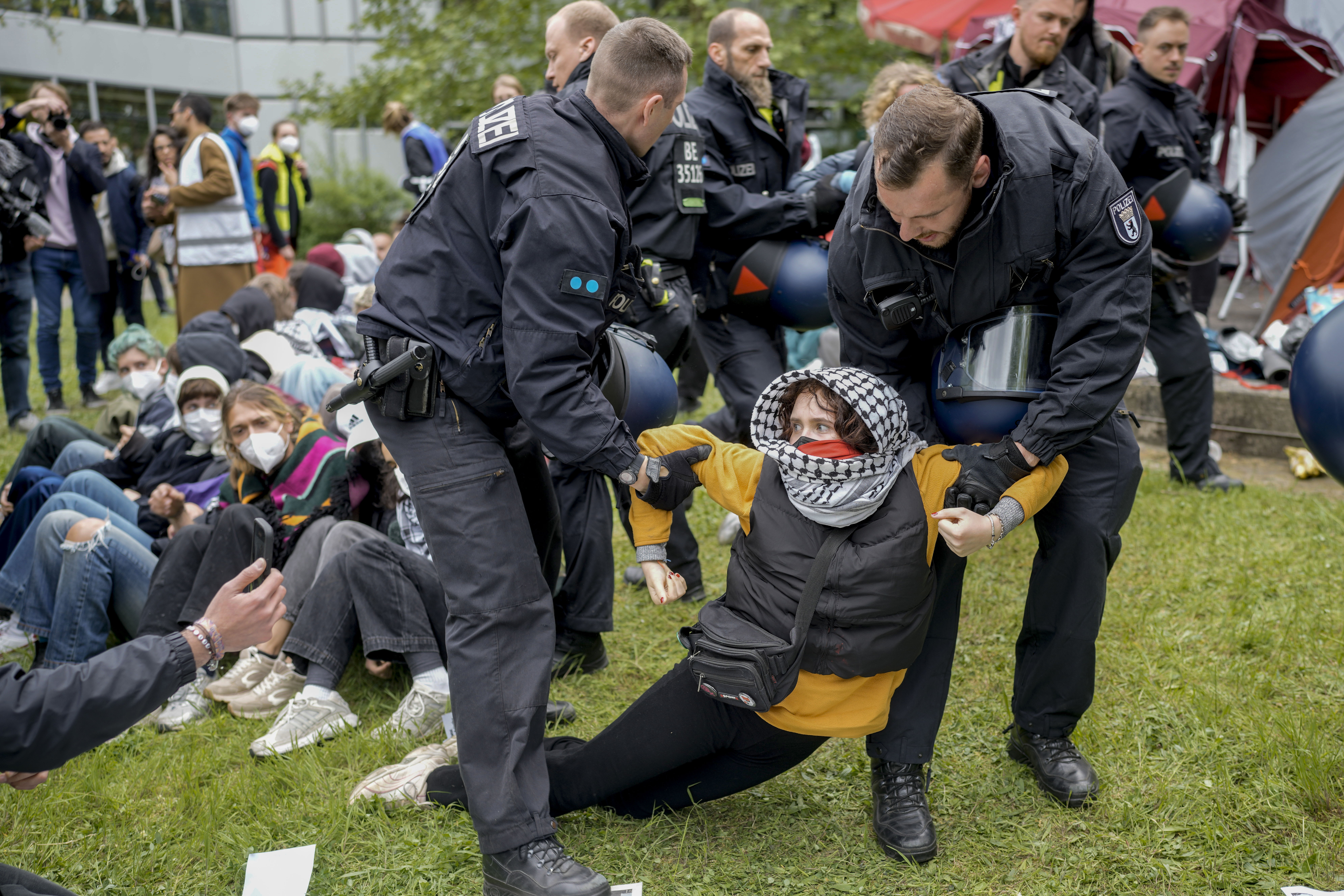 A woman is carried away by police officers during a pro-Palestinians demonstration by the group "Student Coalition Berlin" in the theater courtyard of the 'Freie Universität Berlin' university in Berlin, Germany, Tuesday, May 7