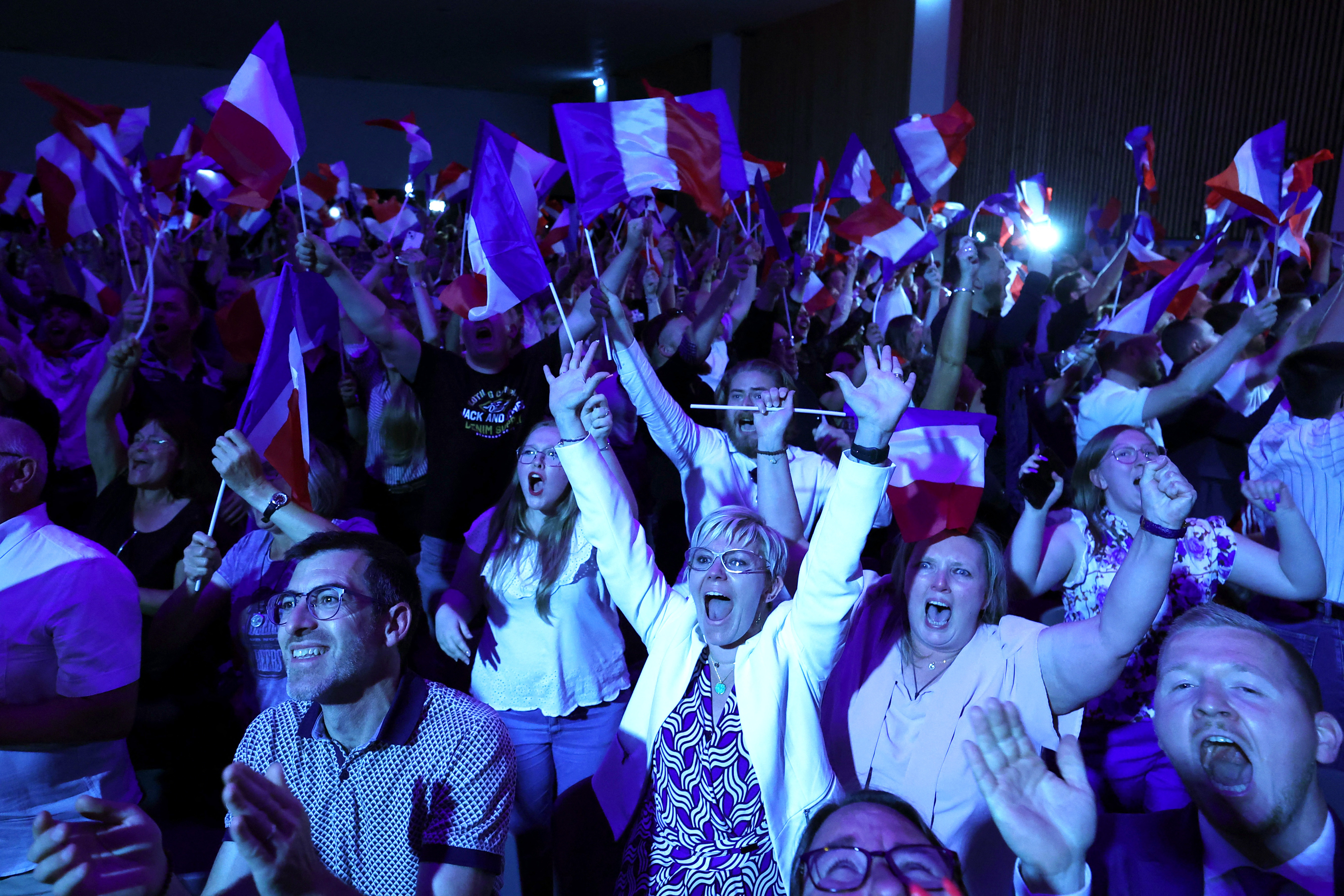 Supporters of Marine Le Pen, French far-right leader and far-right Rassemblement National (National Rally - RN) party candidate, celebrate after partial results in the first round of the early French parliamentary elections, in Henin-Beaumont, France, June 30, 2024. REUTERS/Yves Herman