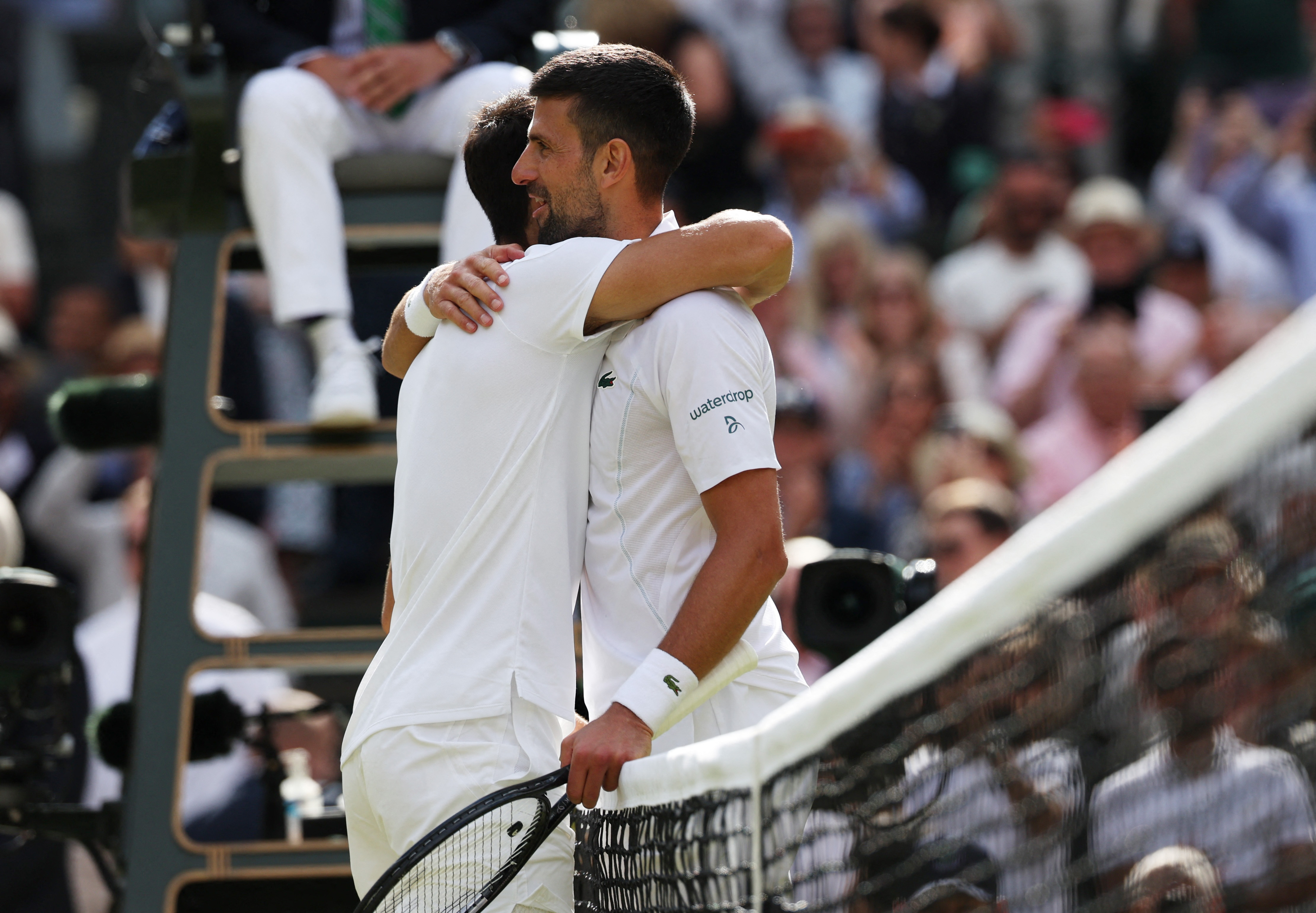 Tennis - Wimbledon - All England Lawn Tennis and Croquet Club, London, Britain - July 14, 2024 Spain's Carlos Alcaraz consoles Serbia's Novak Djokovic after winning the men's singles final REUTERS/Paul Childs