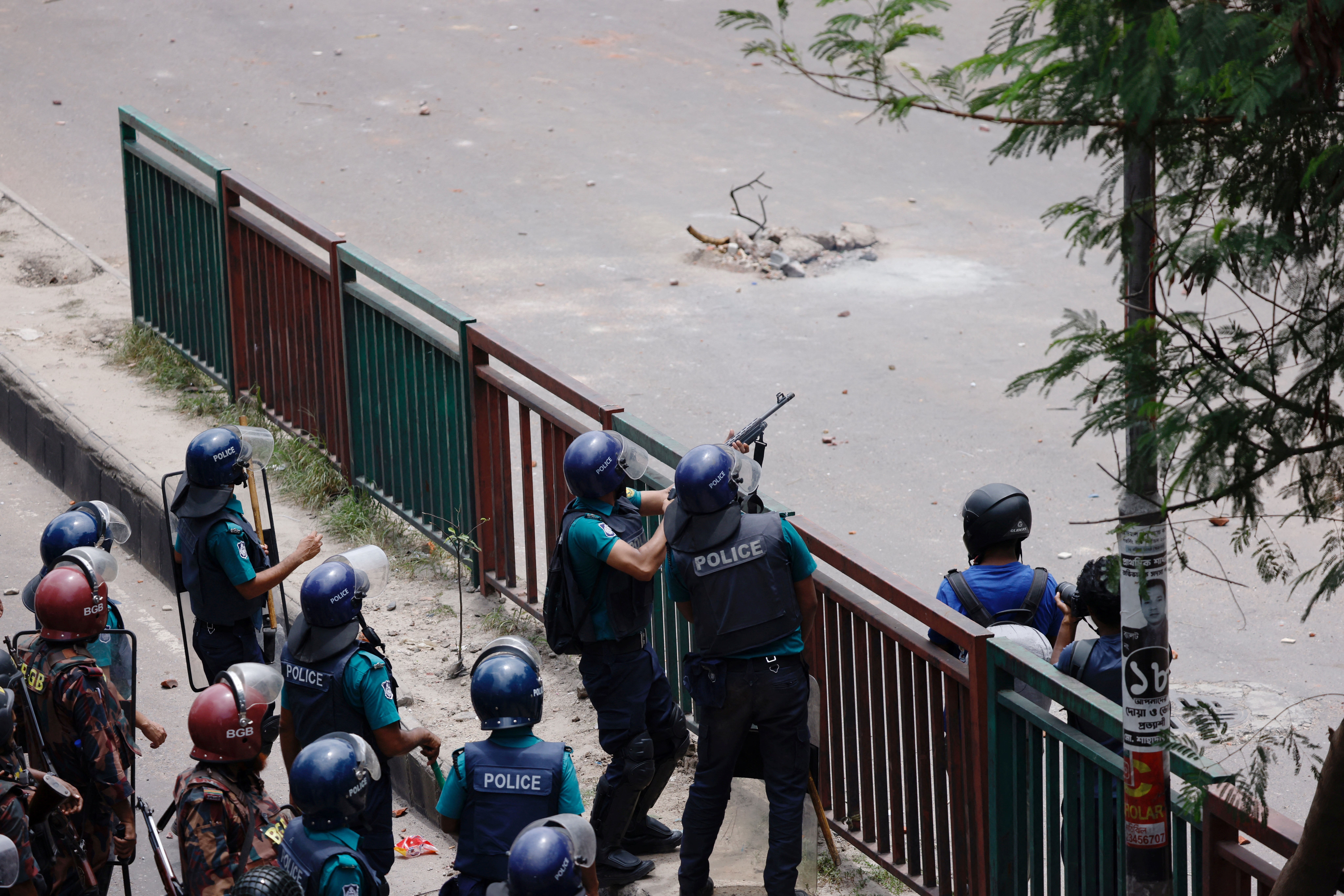 Border Guard Bangladesh forces and police operate in front of the state-owned Bangladesh Television as violence erupts across the country