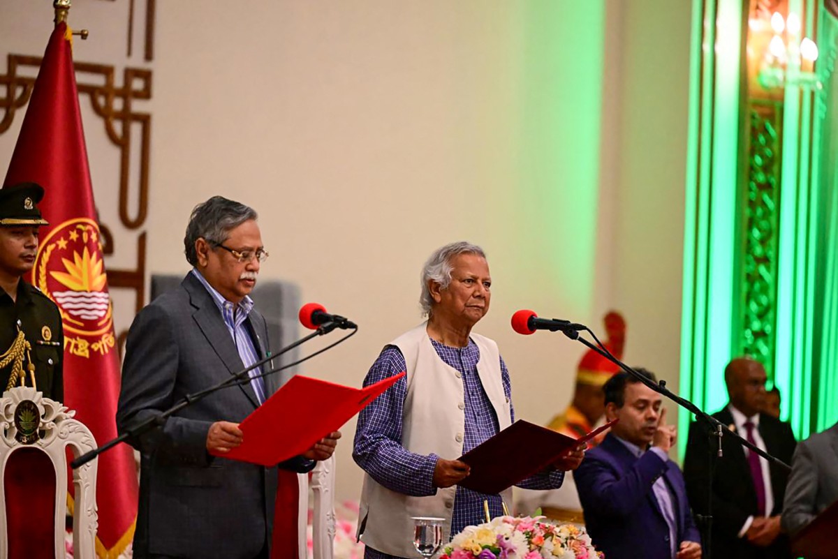 Nobel laureate Muhammad Yunus (C) is sworn in as the chief adviser of the new interim government of Bangladesh in Dhaka on August 8, 2024, as President Mohammed Shahabuddin (2L) administers the oath taking ceremony. - Nobel Peace Prize winner Muhammad Yunus was sworn into office on August 8 to lead Bangladesh's interim government as its chief adviser, days after a student-led uprising ended the 15-year rule of Sheikh Hasina. (Photo by Munir UZ ZAMAN / AFP)