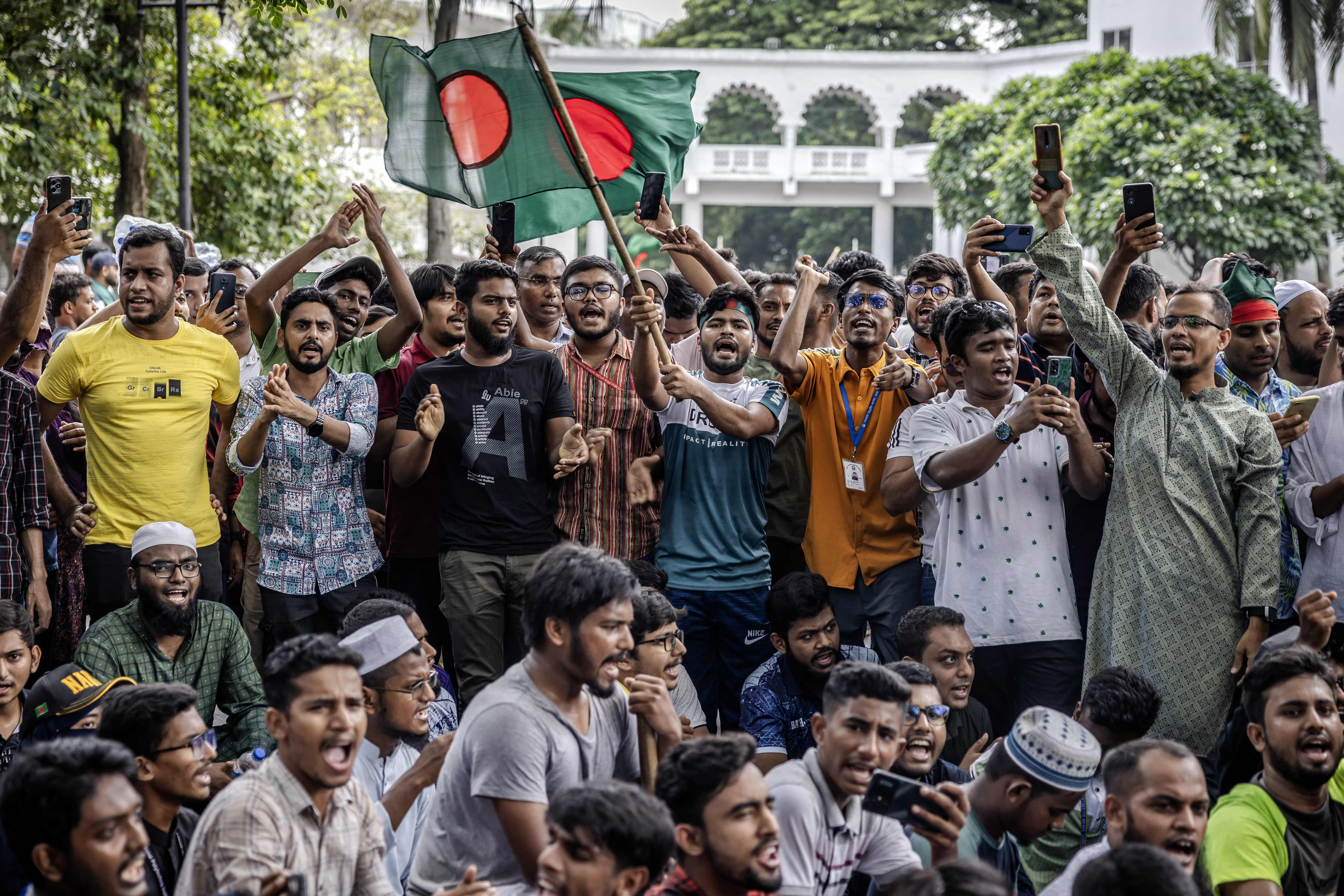 Students hold Bangladesh's national flags as they protest to demand the resignation of Chief Justice Obaidul Hassan