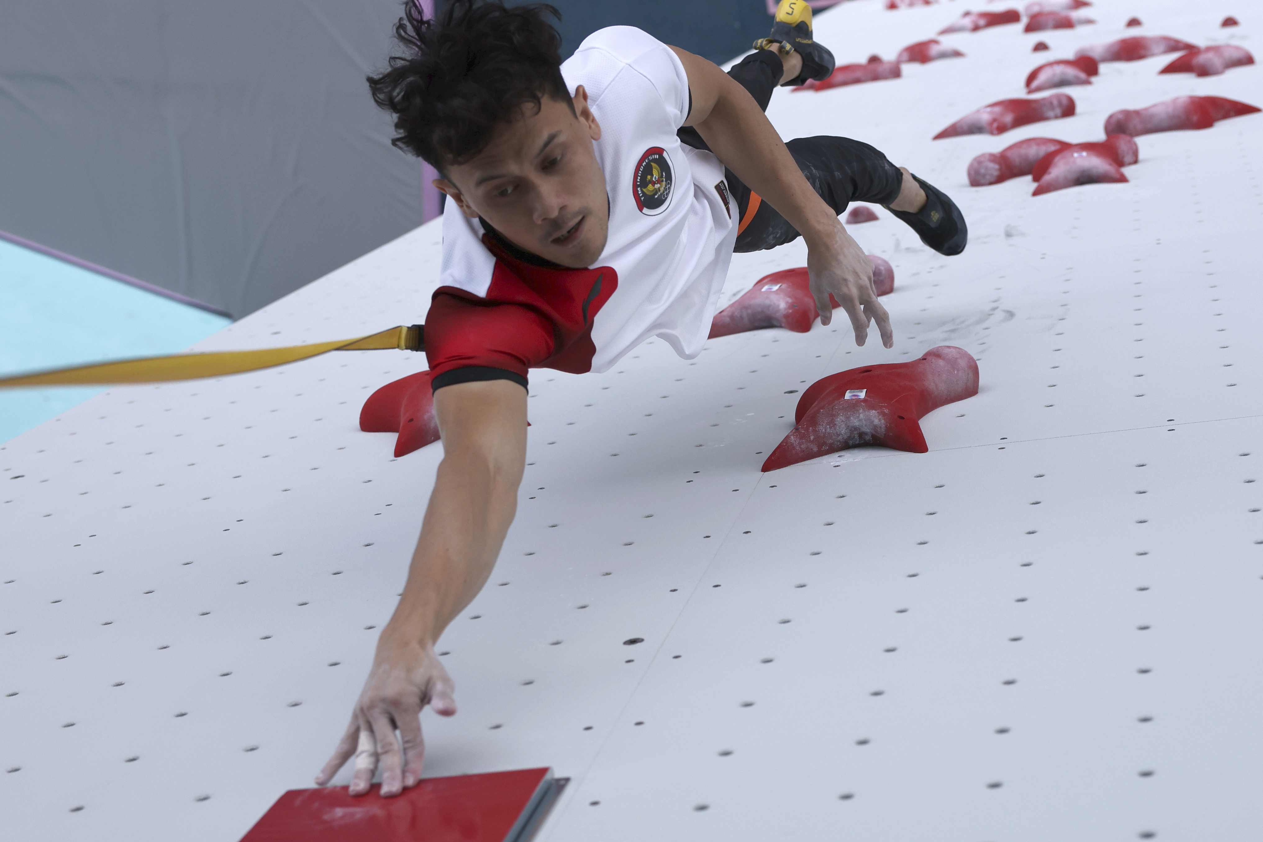 Veddriq reaches the top of the 15-metre wall in the men’s speed climbing final