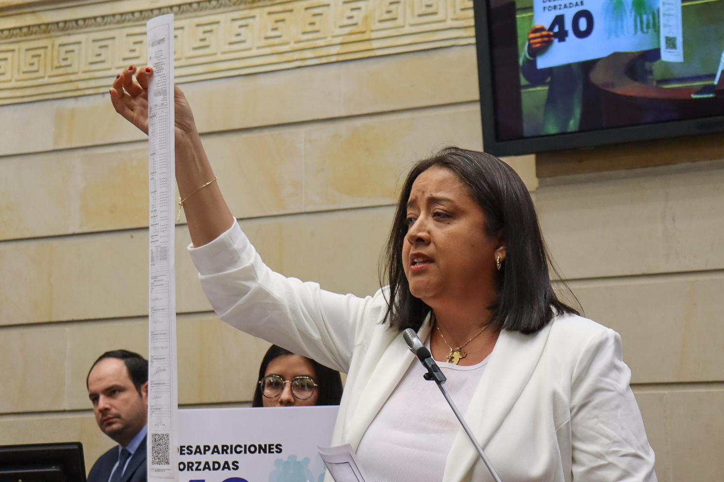 Gaby Arellano speaks to the Colombian senate, holding up a long slim sheet of paper representing Venezuelan voting results.