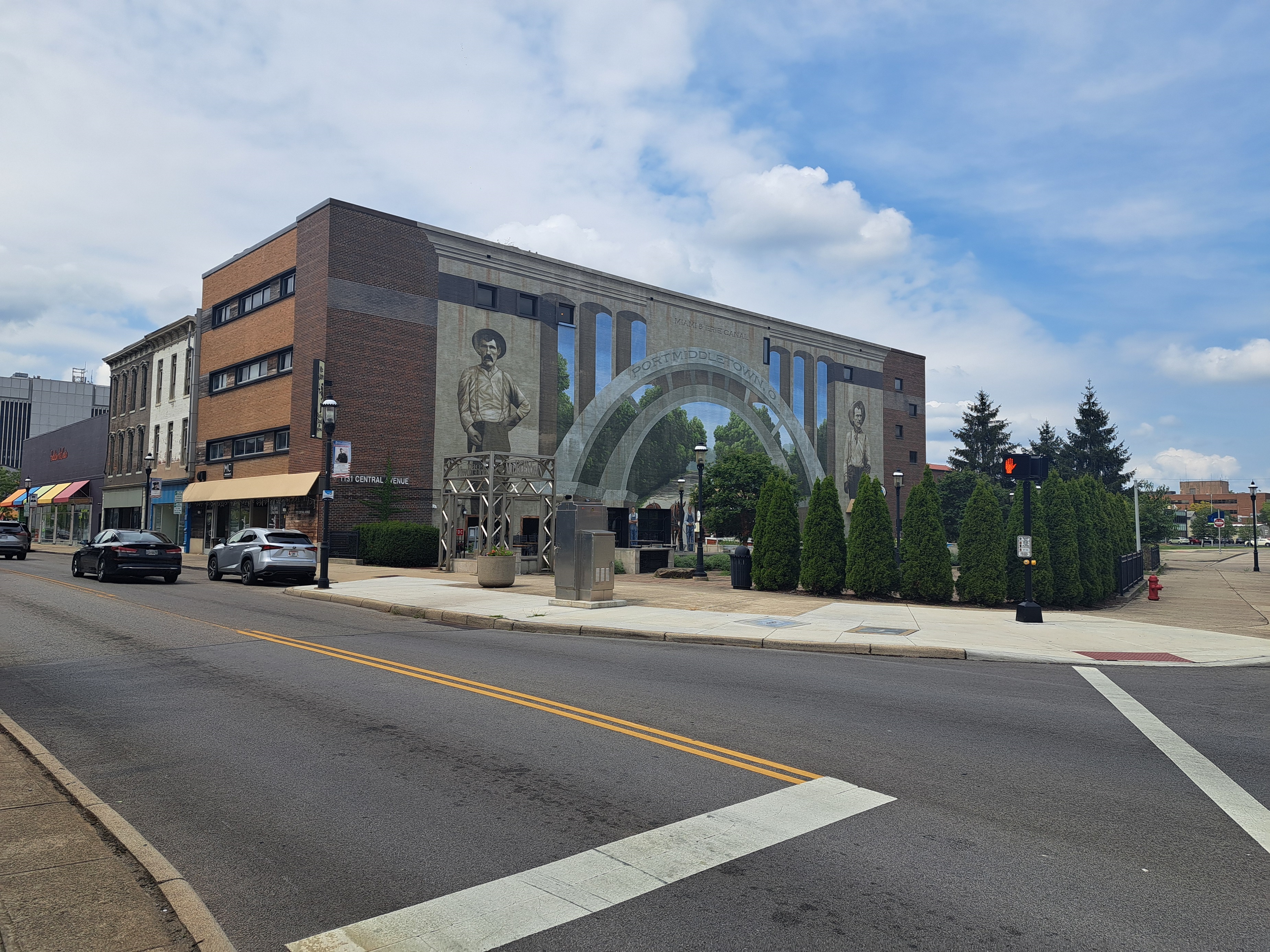 A view of Central Avenue in Middletown, Ohio, where a brick building shows a mural of working-class laborers.