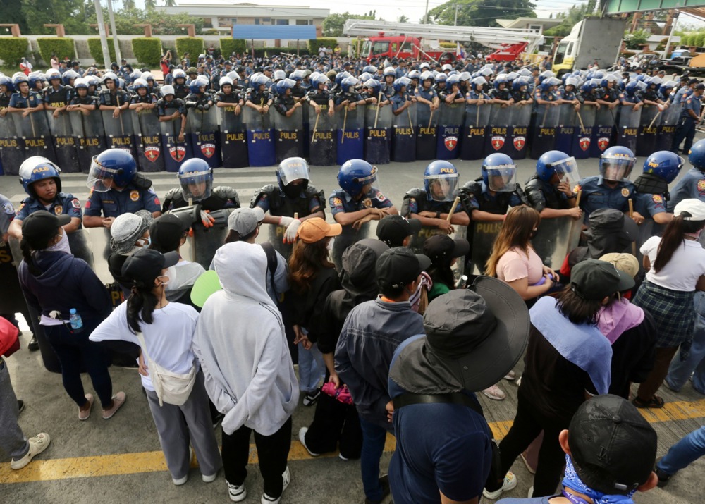 epa11565411 Anti-riot police block supporters of religious leader Apollo Quiboloy as they stage a protest rally outside the Kingdom of Jesus Christ (KOJC) compound in Davao city, Davao del Sur province, about 1,500 kilometers south of Manila, Philippines, 26 August 2024. The Philippine National Police (PNP) are searching the 30-hectare Kingdom of Jesus Christ (KOJC) compound to arrest KOJC leader Pastor Apollo Quiboloy, who claims he is the ‘Son of God’. Quiboloy and five other KOJC members are facing charges of child abuse and human trafficking. EPA-EFE/CERILO EBRANO