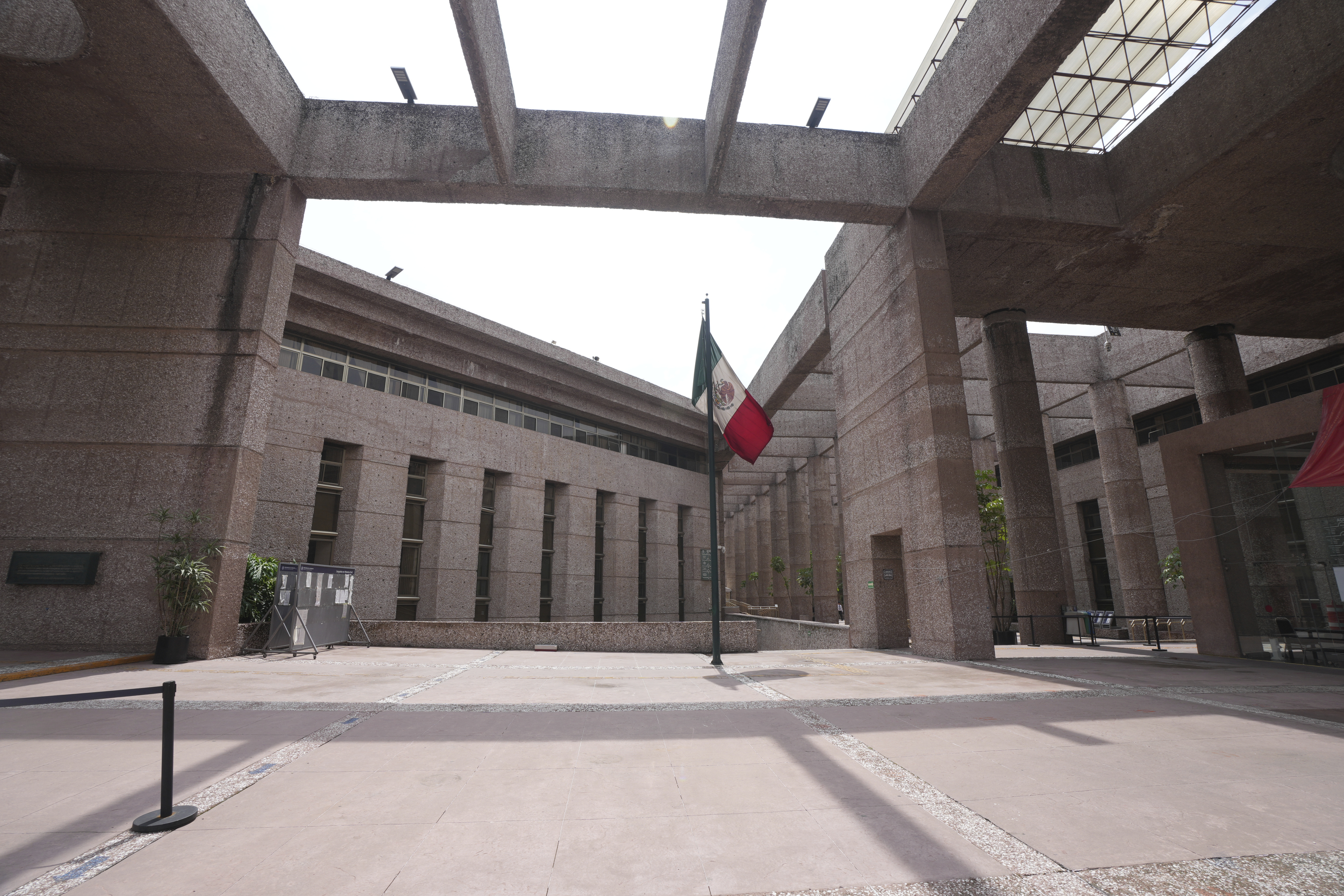 A Mexican flag stands amid the empty corridors of the federal court during a workers’ strike over the reforms