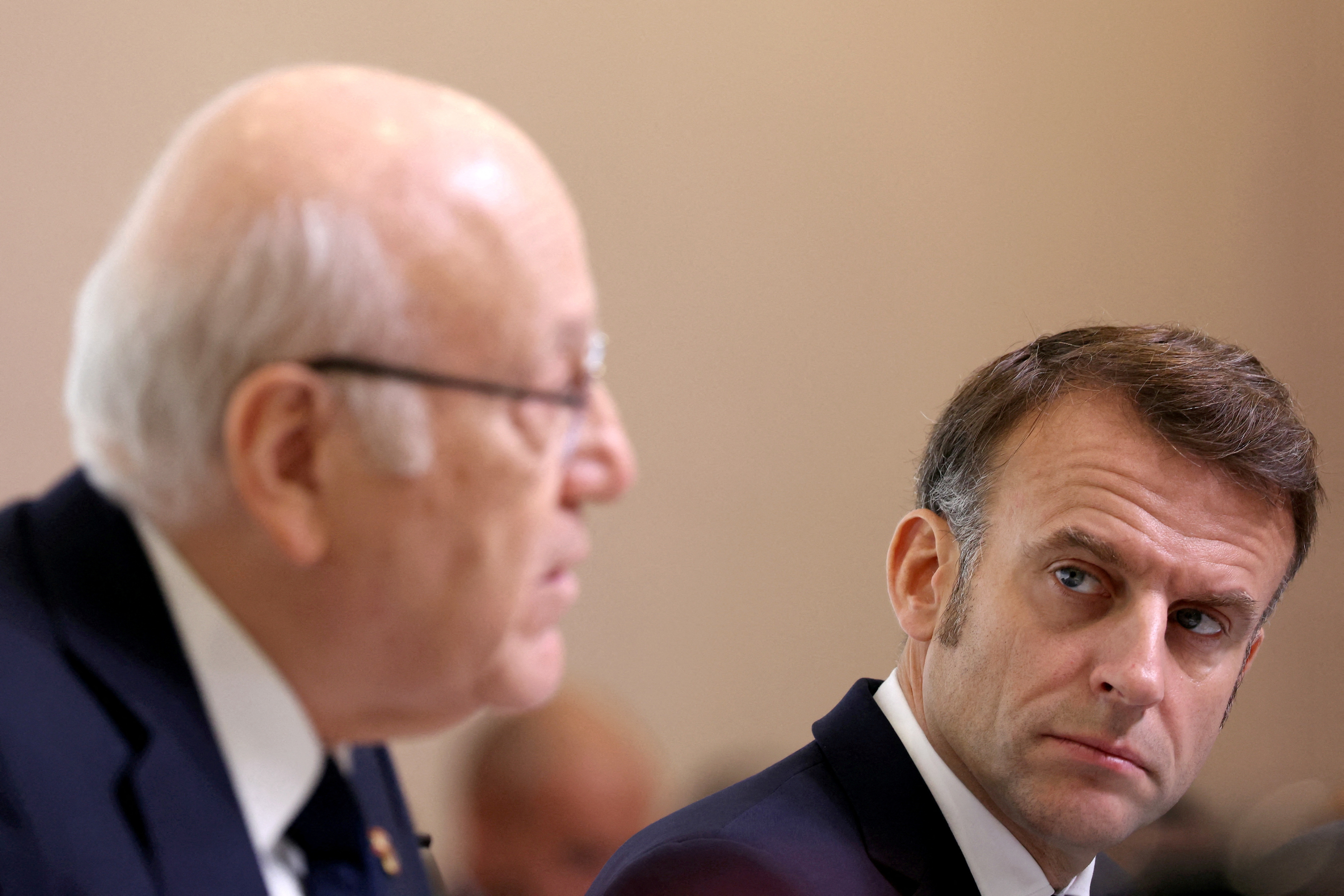 French President Emmanuel Macron (R) looks on as Lebanon's caretaker Prime Minister Najib Mikati speaks
