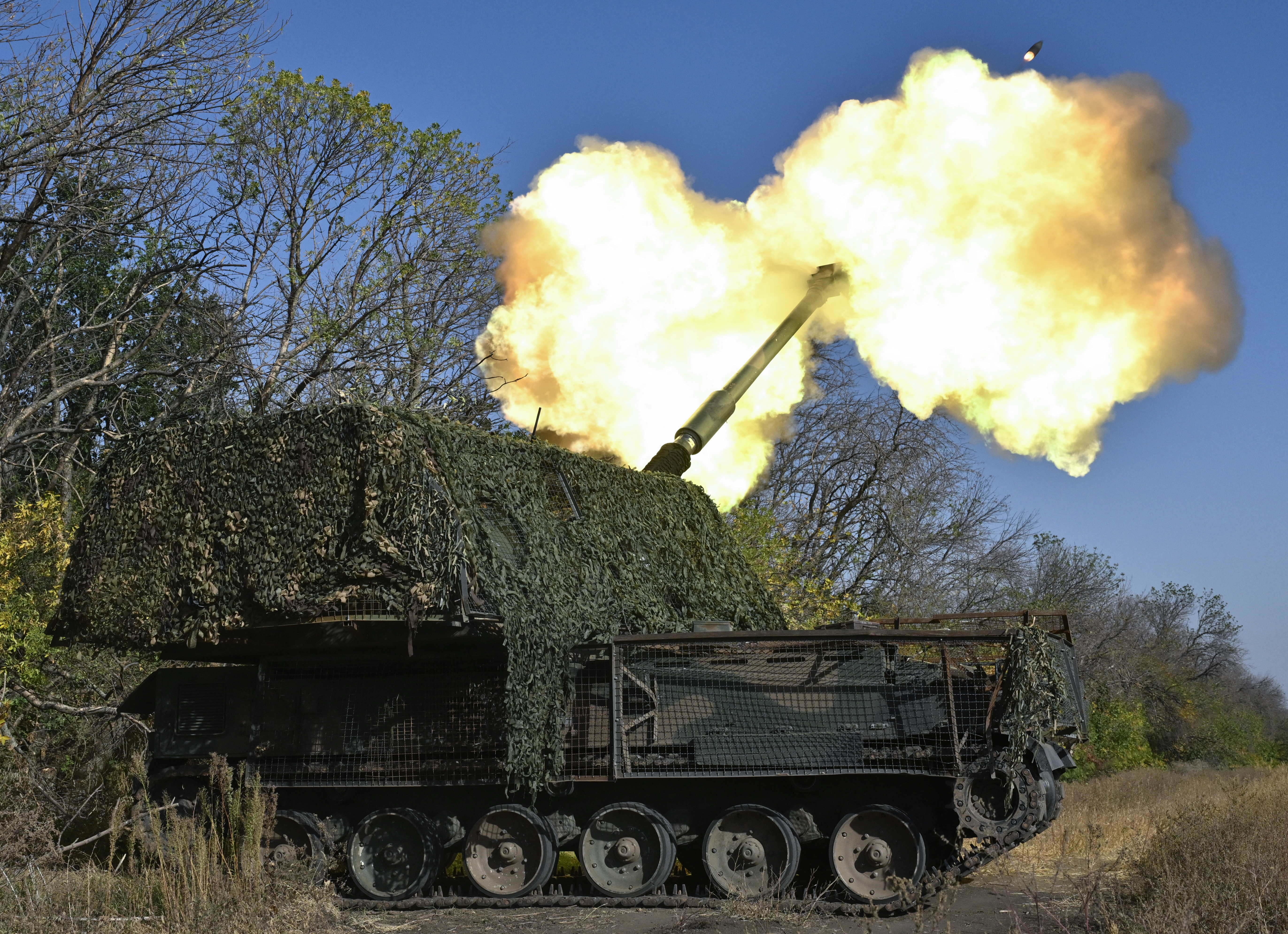 A Ukrainian brigade firing a howitzer on the front line in eastern Ukraine. There is fire and smoke coming from the barrel