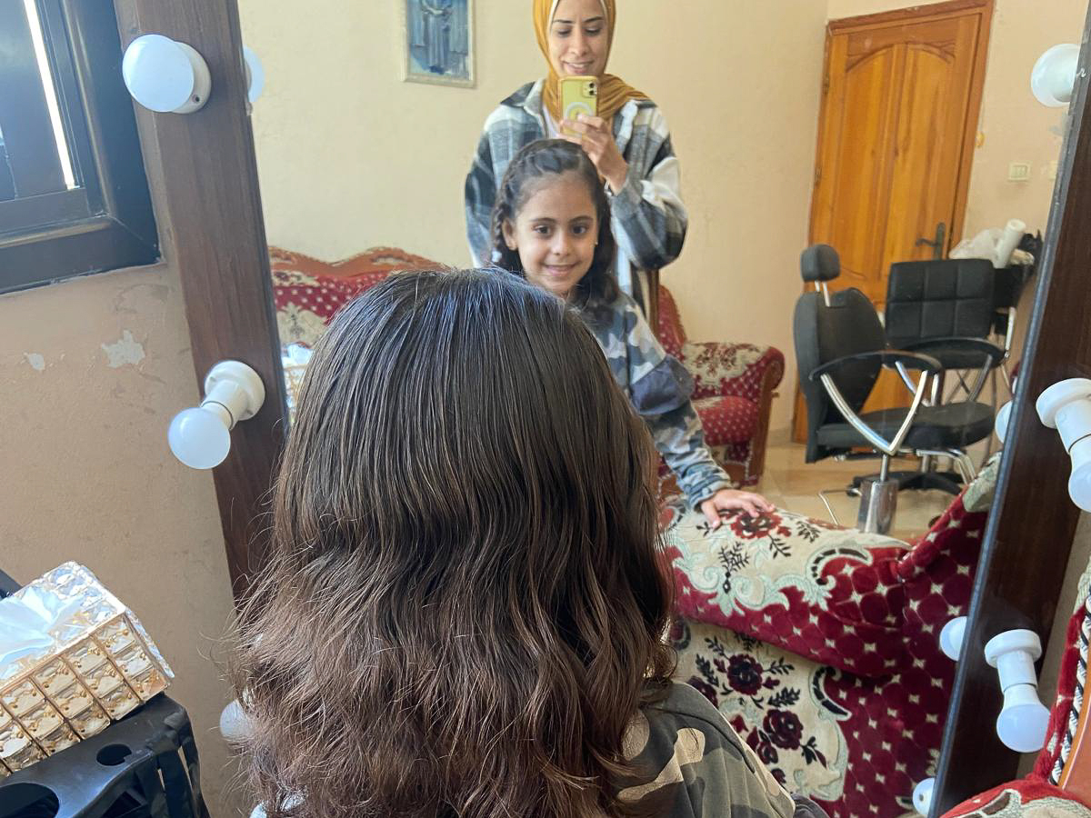 Maram Humaid's daughter getting her hair cut at a makeshift hairdresser in Deir el-Balah, Gaza, as Israel's war continues