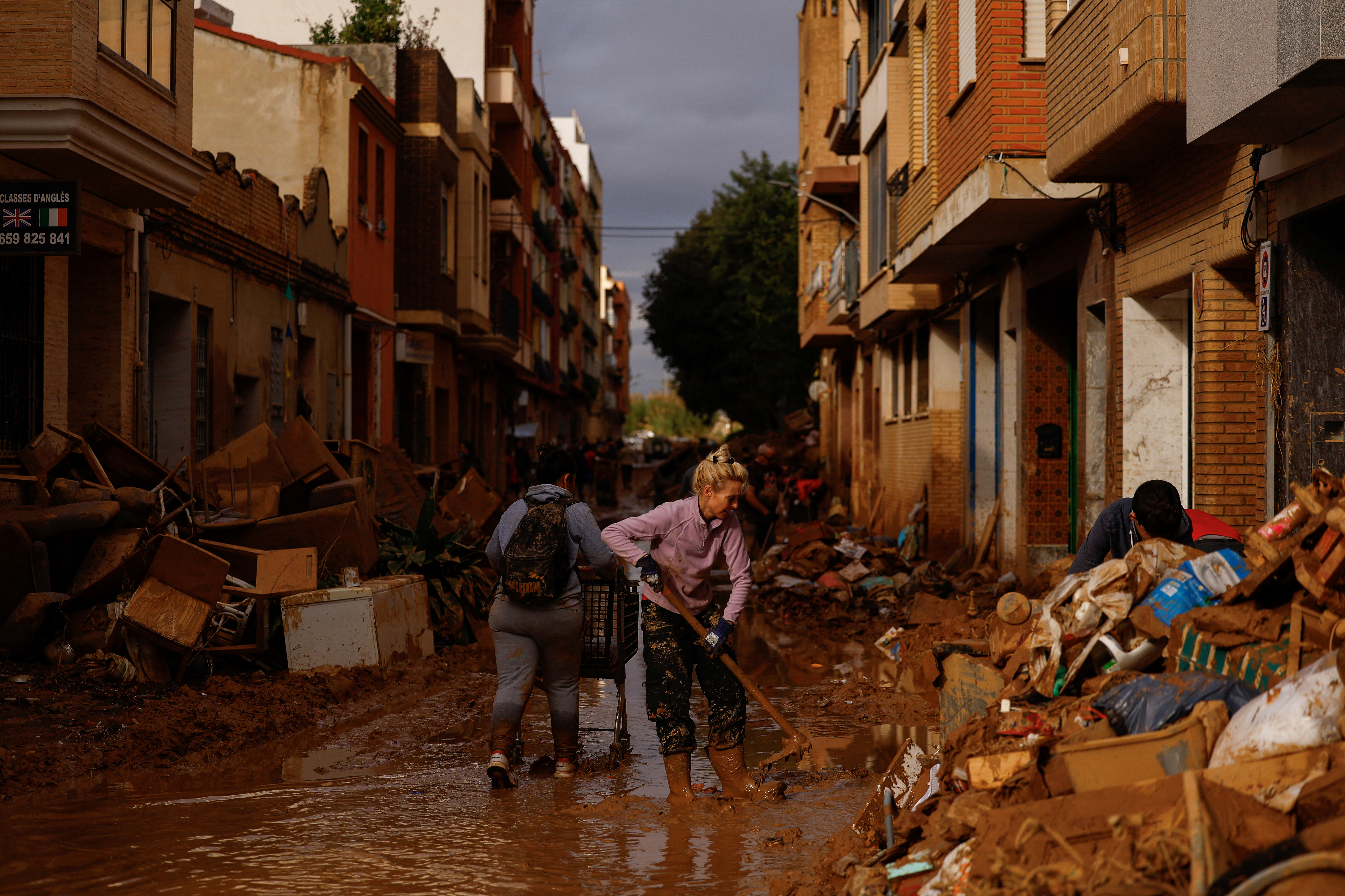 A woman cleans thick mud, in the aftermath of floods caused by heavy rains, in Sedavi, near Valencia, Spain