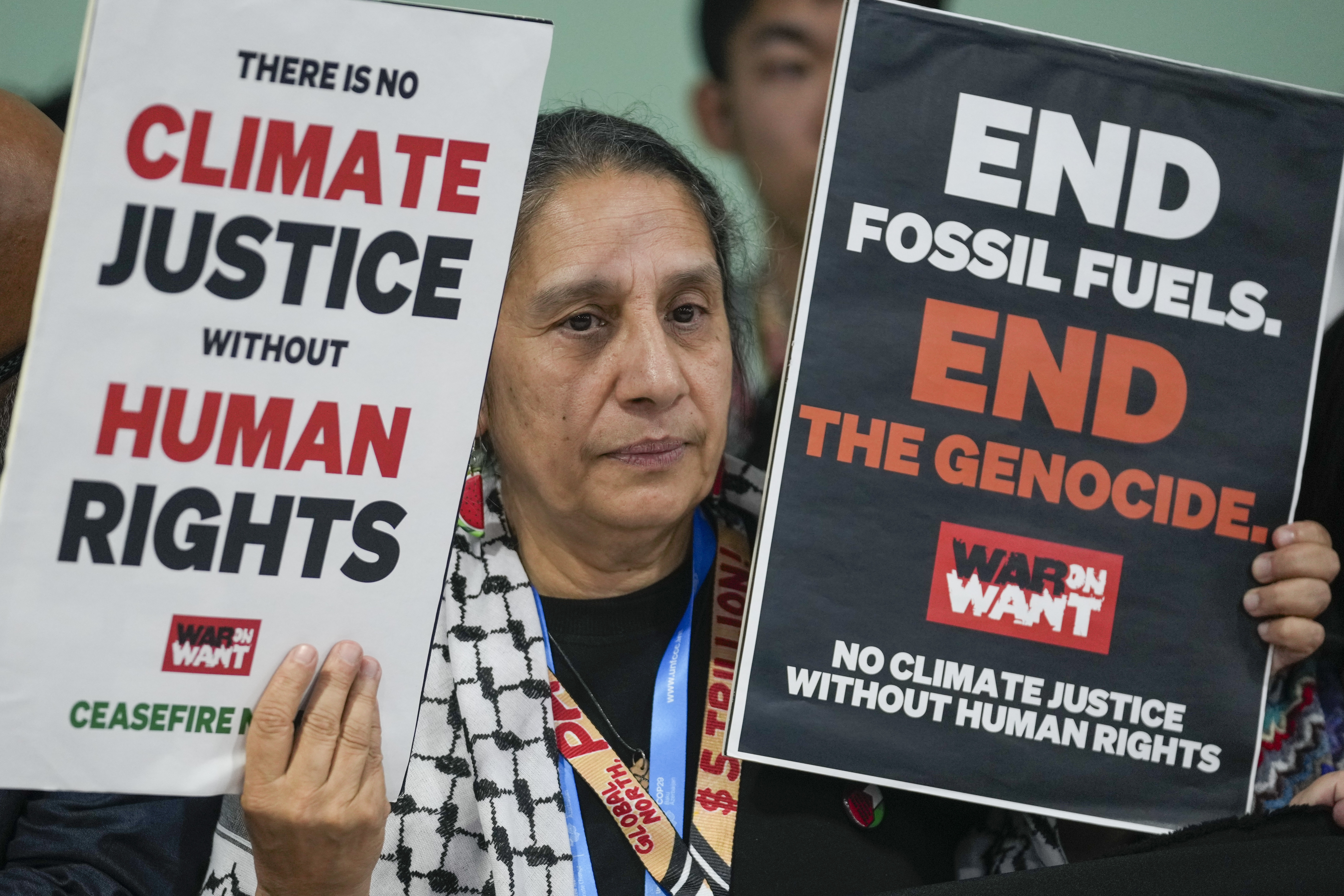 An activist demonstrates for climate justice and a ceasefire in Gaza at the UN Climate Summit on November 11, 2024 in Baku