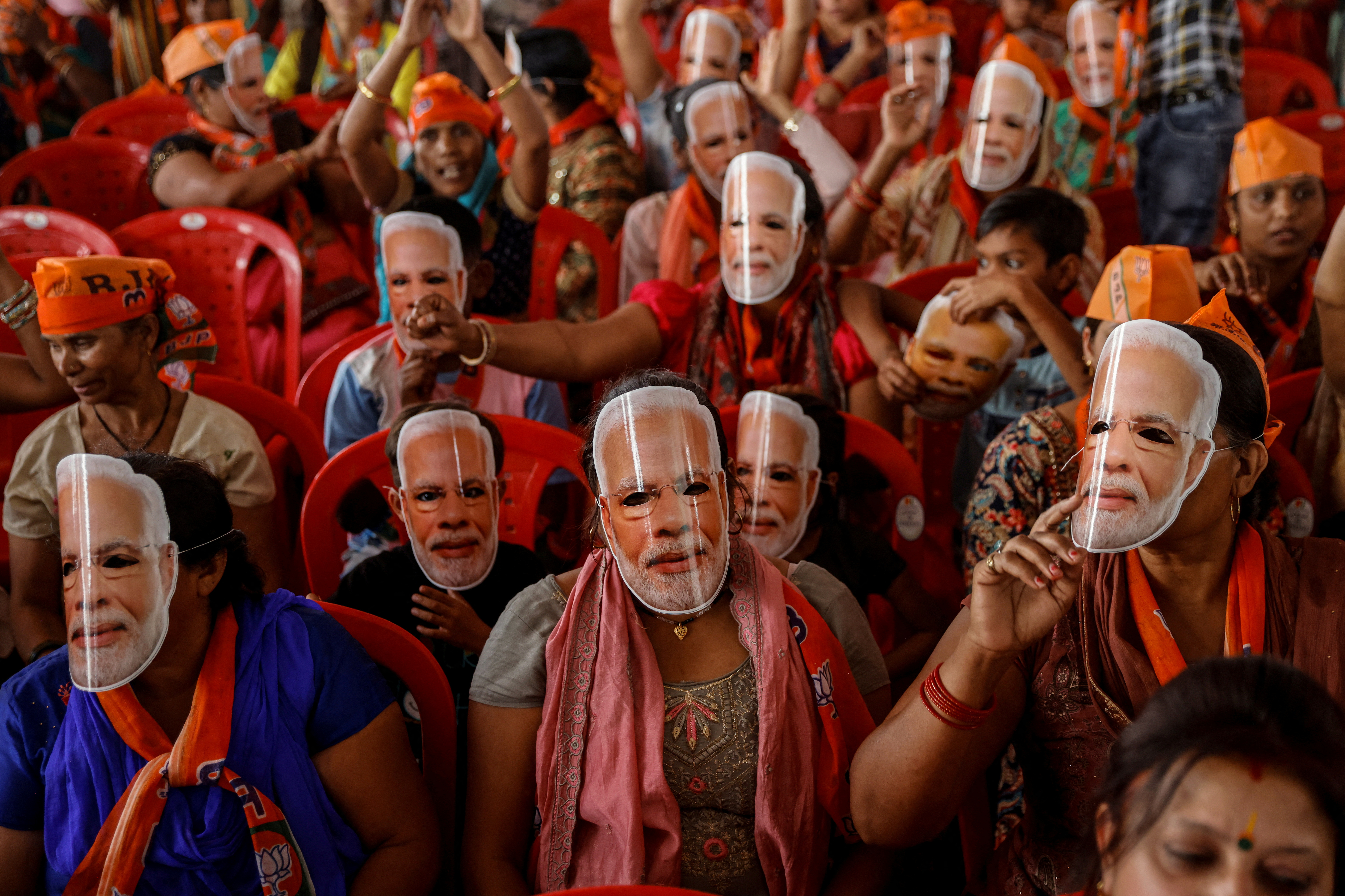 Supporters of India's Prime Minister Narendra Modi wear masks of his face, as they attend an election campaign rally in Meerut, India, March 31