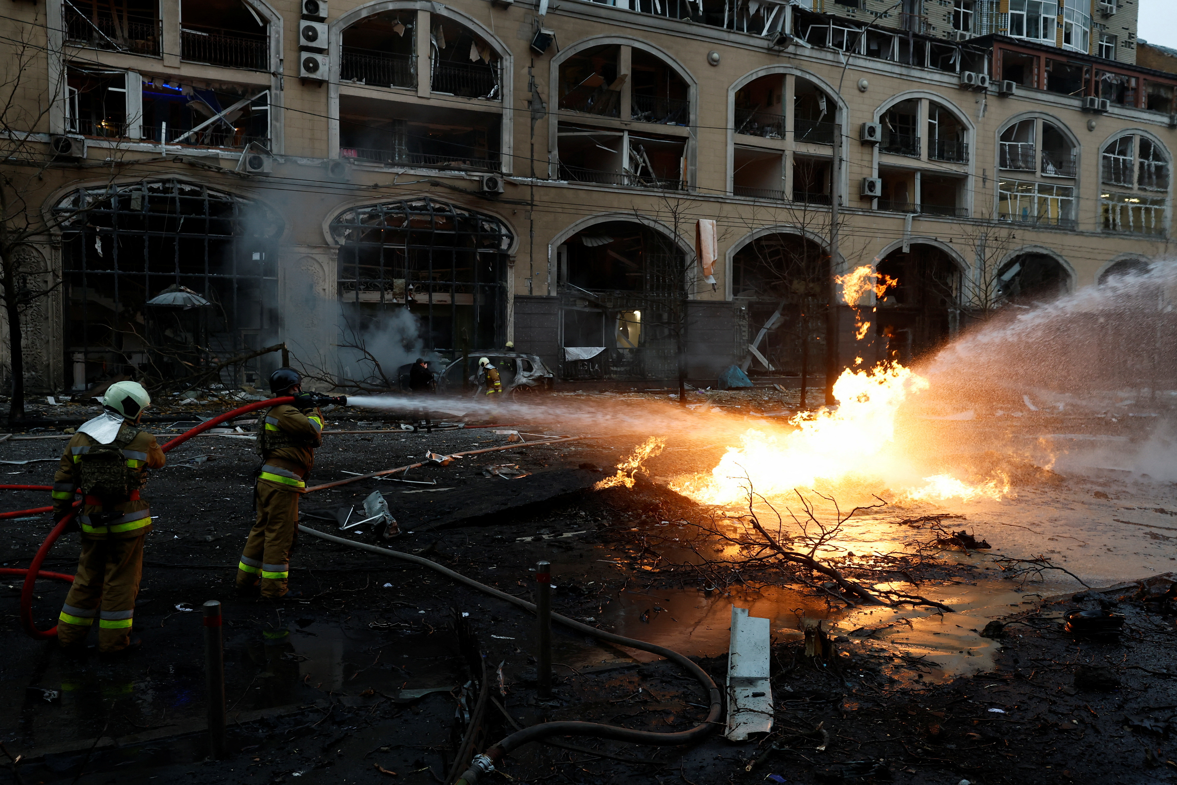 Firefighters work to extinguish a fire near the site of a destroyed building