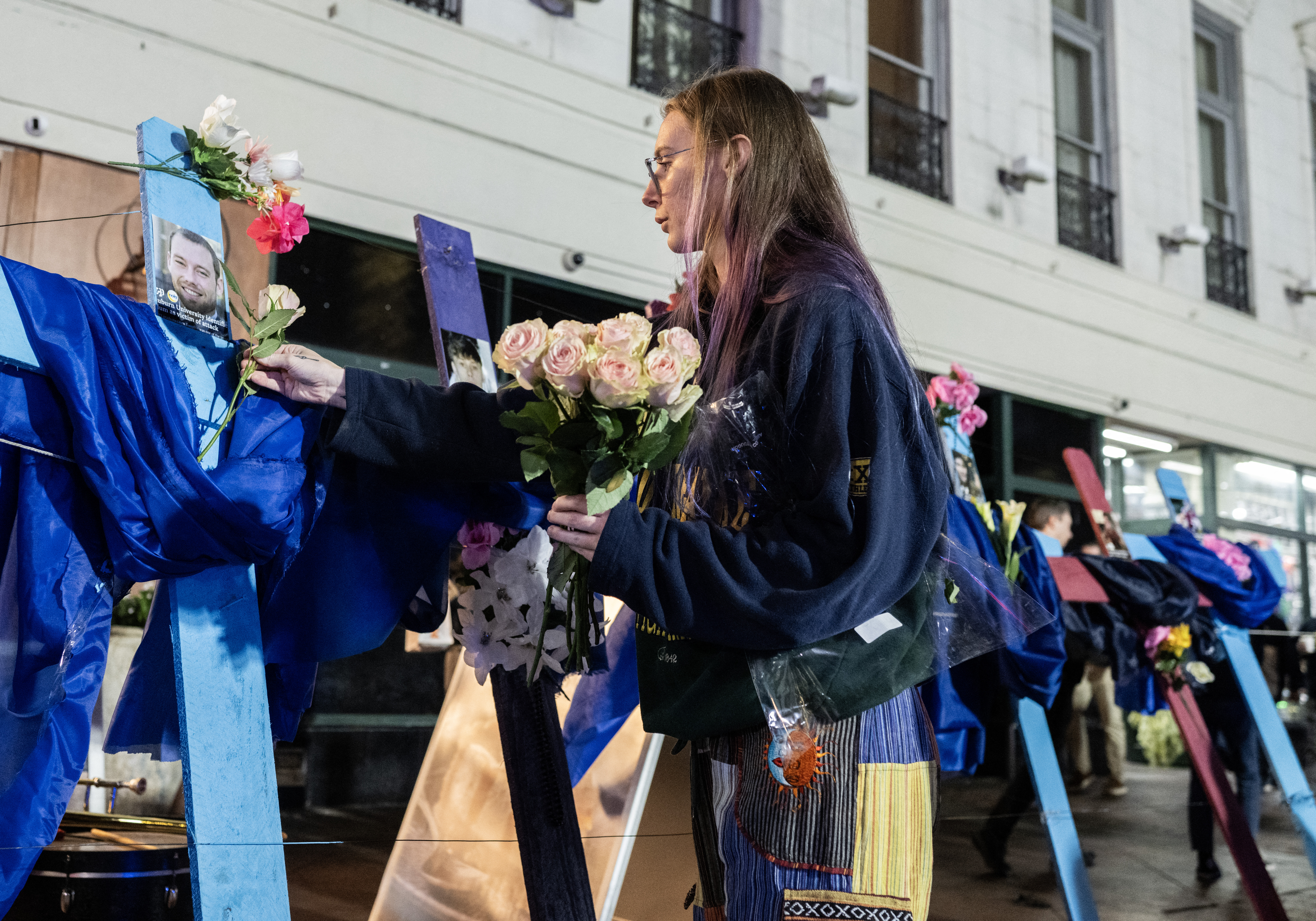 A woman places flowers on crosses with pictures of victims at a memorial on Bourbon Street after it reopened to the public on January 2