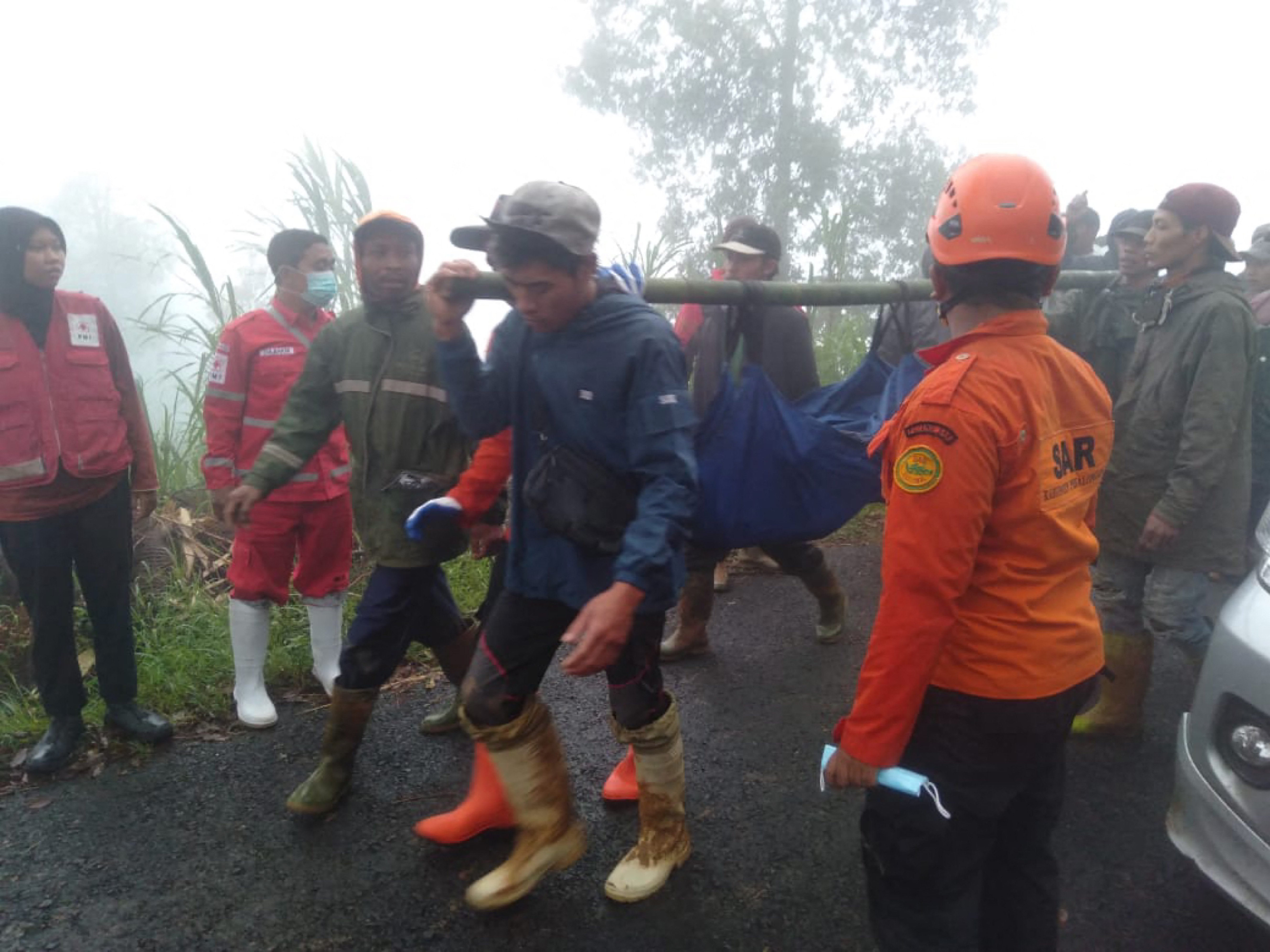 In this handout picture taken and released on January 21, 2025, by the Indonesias Disaster Mitigation Agency shows, rescueers and villagers evacuate victims of a landslide at Kasimpar Village in Pekalongan, Central Java. At least 16 people have been killed and three more are missing after a landslide triggered by heavy rain in Indonesias Central Java province, disaster officials said