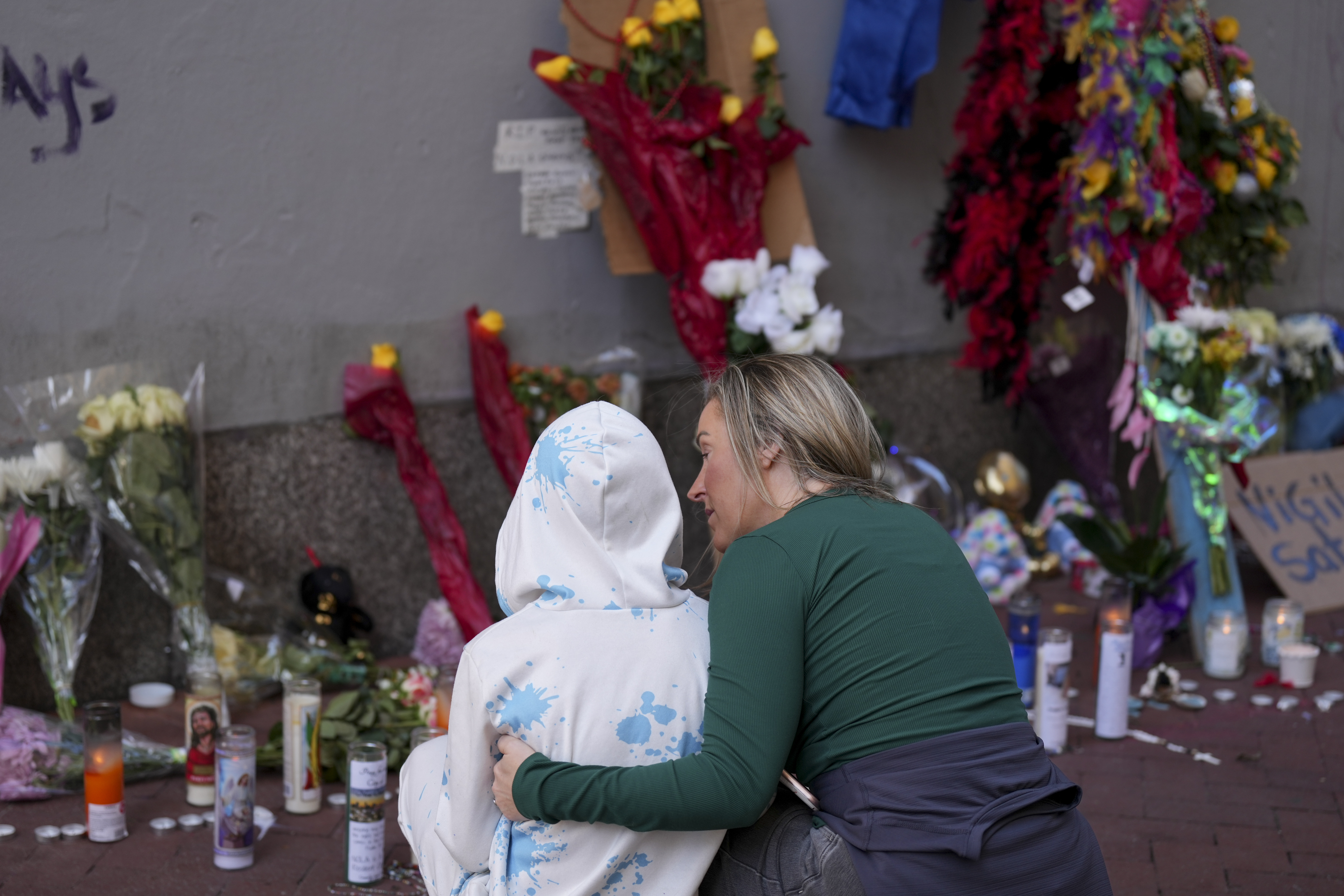 Kelli Galle, right, hugs her son Parker, left, as they visit a memorial to the victims of a deadly truck attack on Bourbon Street in the French Quarter, Friday, Jan. 3