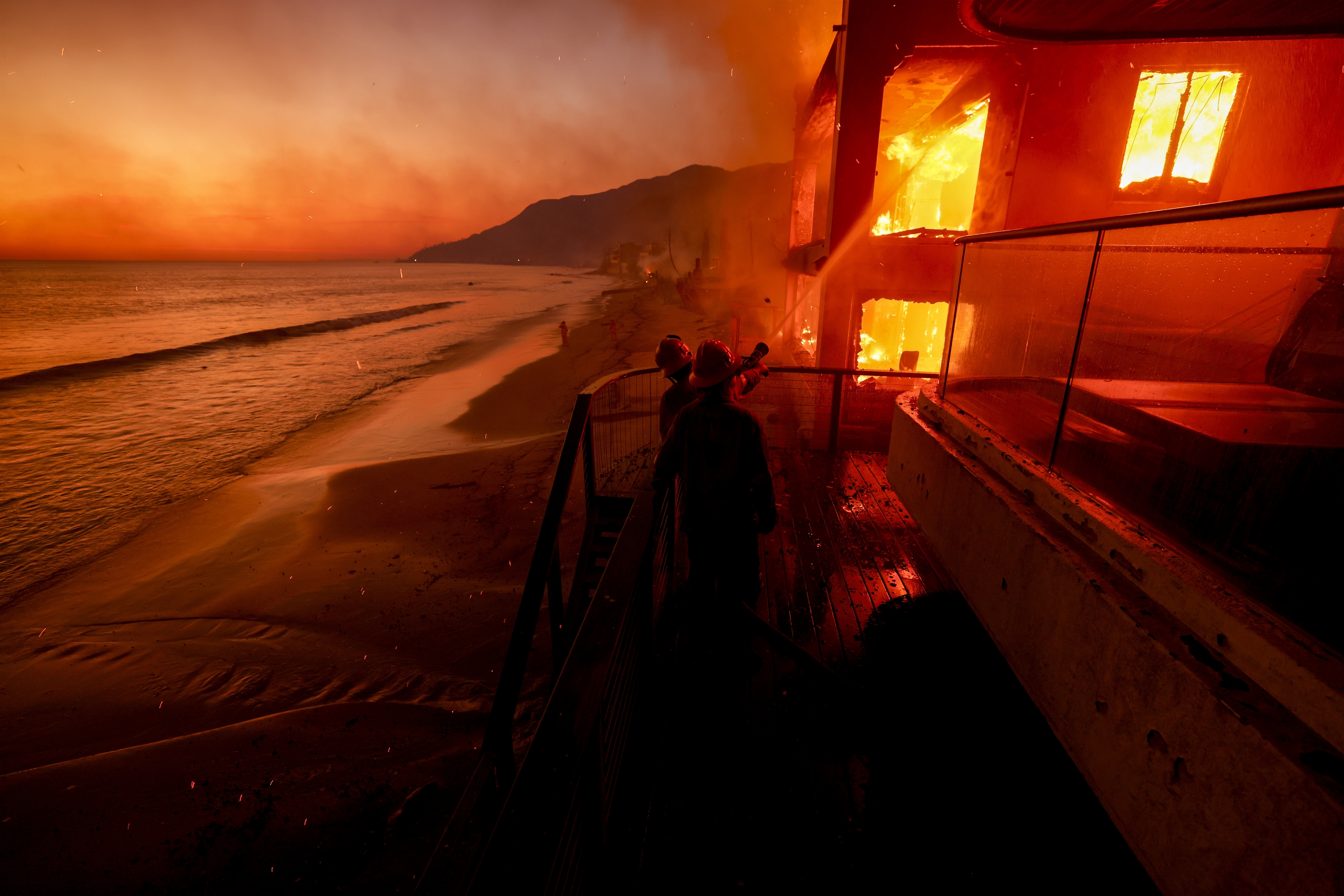 a burning building next to the sea