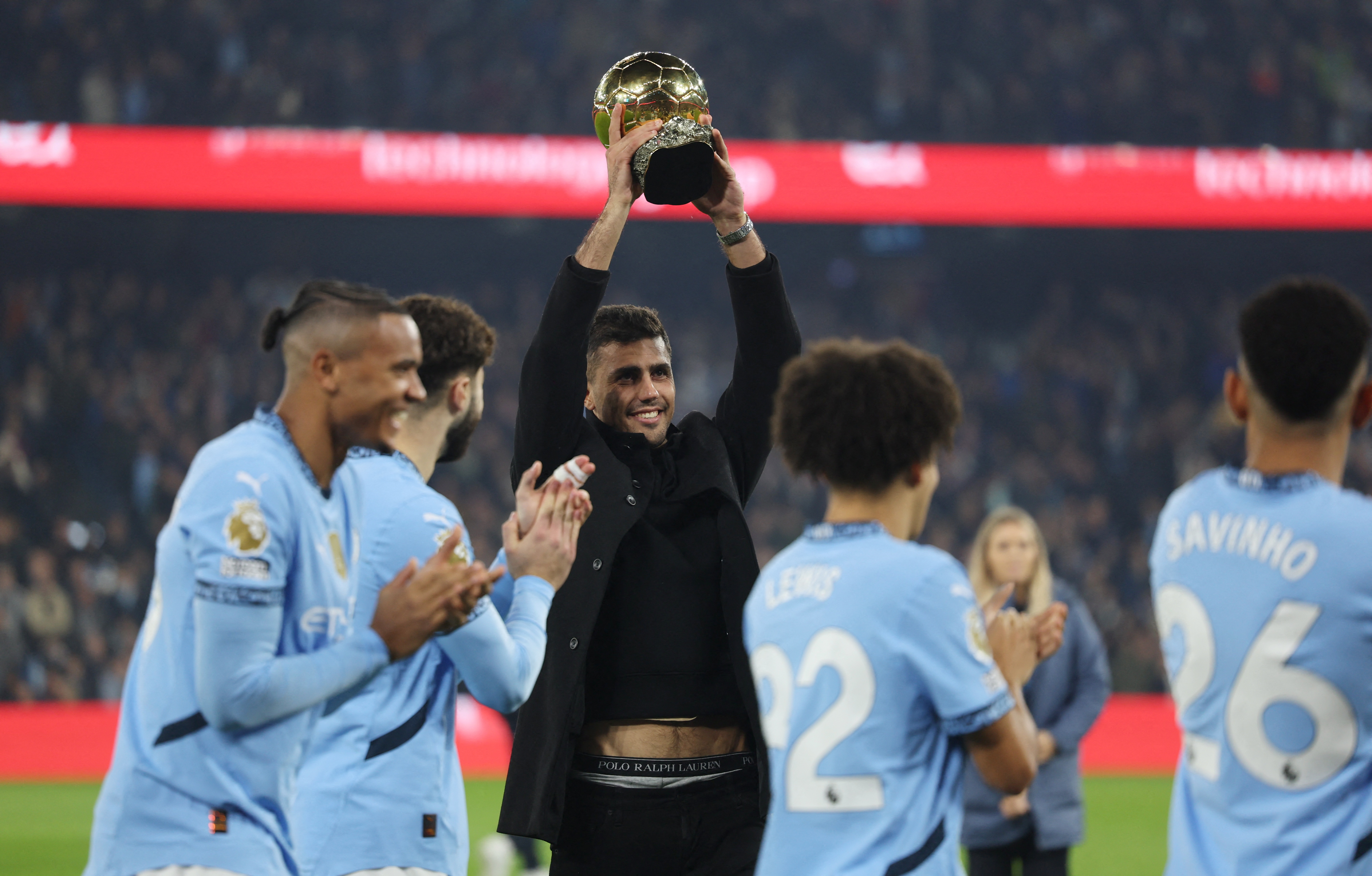 Soccer Football - Premier League - Manchester City v Tottenham Hotspur - Etihad Stadium, Manchester, Britain - November 23, 2024 Manchester City's Rodri with the Ballon d'Or trophy on the pitch before the match Action Images via Reuters/Lee Smith EDITORIAL USE ONLY. NO USE WITH UNAUTHORIZED AUDIO, VIDEO, DATA, FIXTURE LISTS, CLUB/LEAGUE LOGOS OR 'LIVE' SERVICES. ONLINE IN-MATCH USE LIMITED TO 120 IMAGES, NO VIDEO EMULATION. NO USE IN BETTING, GAMES OR SINGLE CLUB/LEAGUE/PLAYER PUBLICATIONS. PLEASE CONTACT YOUR ACCOUNT REPRESENTATIVE FOR FURTHER DETAILS..