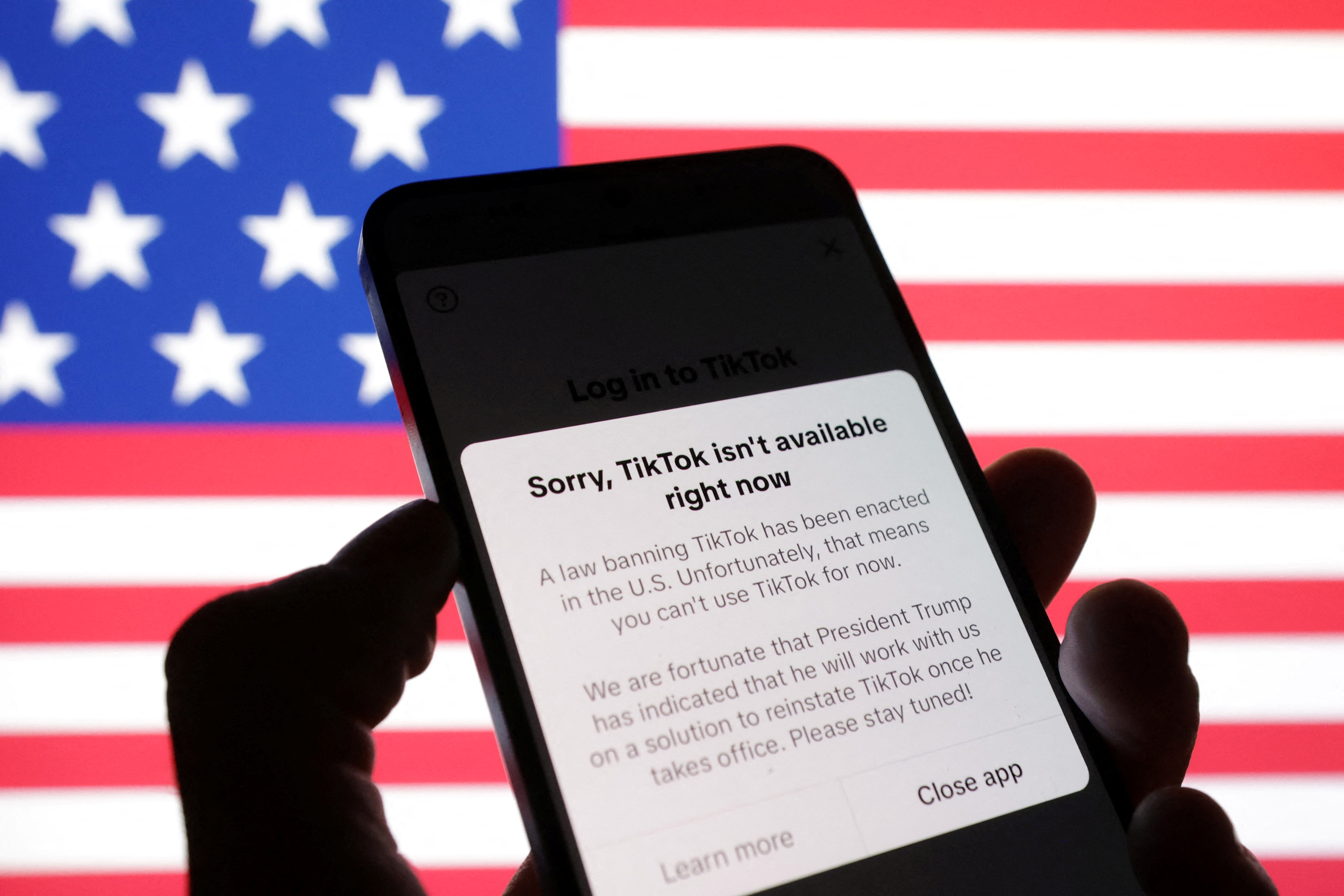 The U.S. flag and TikTok app with the message "Sorry, TikTok isn't available right now"
