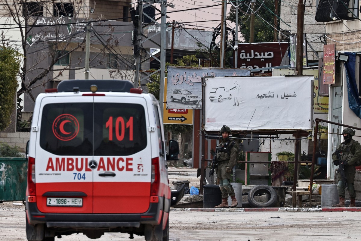 An ambulance drives next to the an Israeli army checkpoint