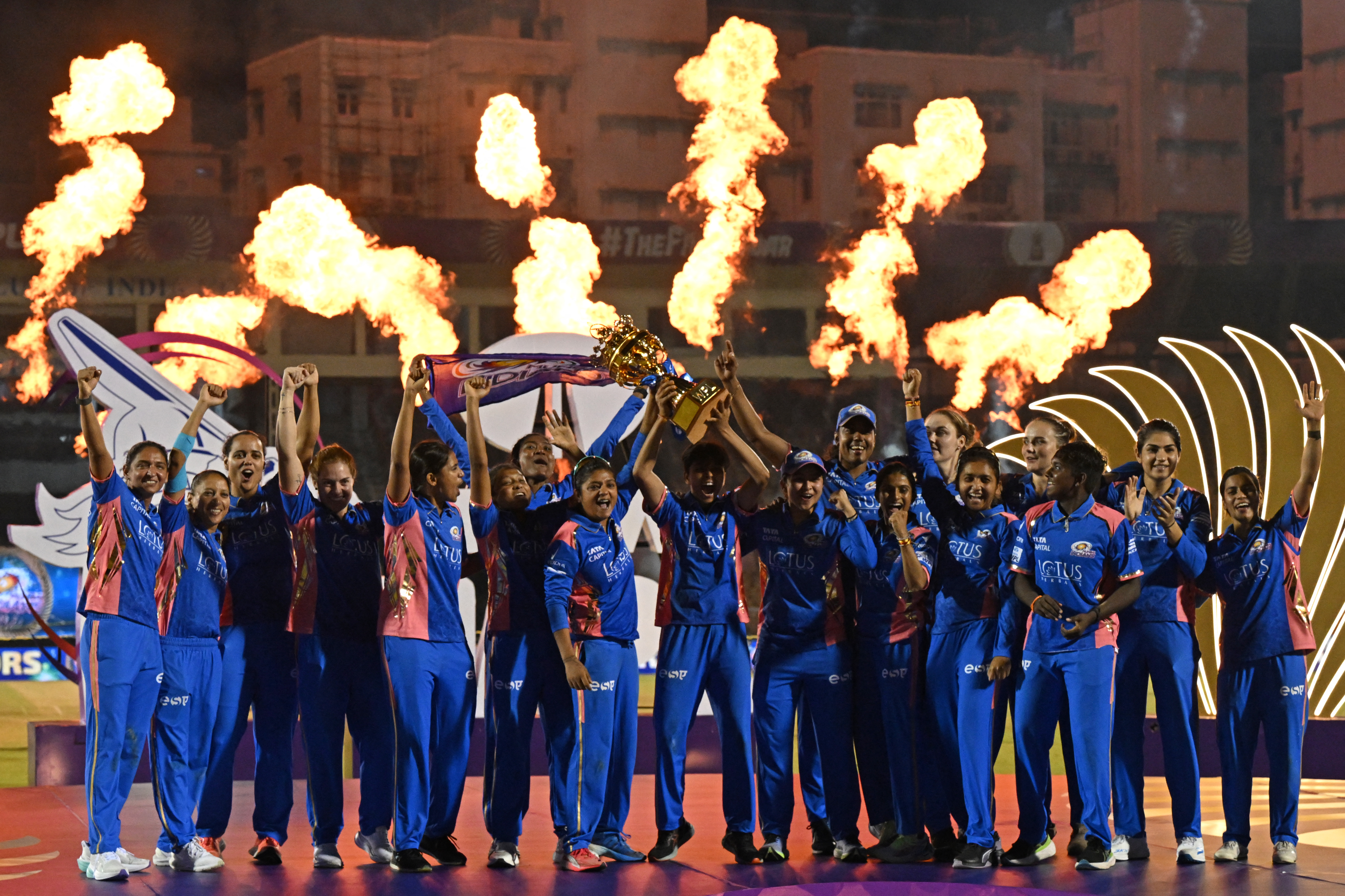 Mumbai Indians players celebrate with the winning trophy at the end of the Women's Premier League (WPL) Twenty20 final cricket match between Mumbai Indians and Delhi Capitals at Brabourne Stadium in Mumbai on March 16, 2025. (Photo by INDRANIL MUKHERJEE / AFP) / -- IMAGE RESTRICTED TO EDITORIAL USE - STRICTLY NO COMMERCIAL USE --