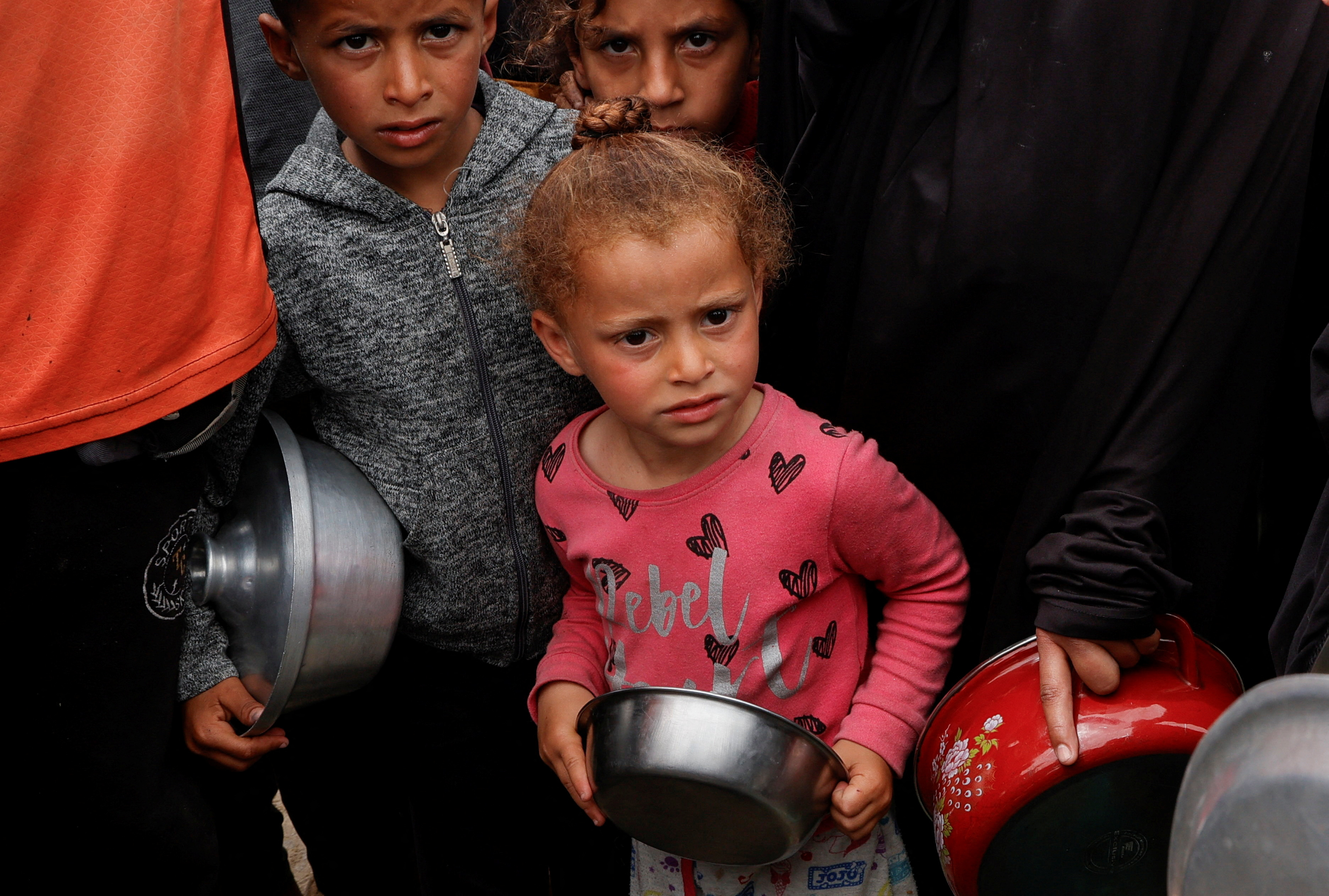 Palestinians gather to receive food cooked by a charity kitchen, in Khan Younis, southern Gaza Strip, April 8, 2025. REUTERS/Hatem Khaled