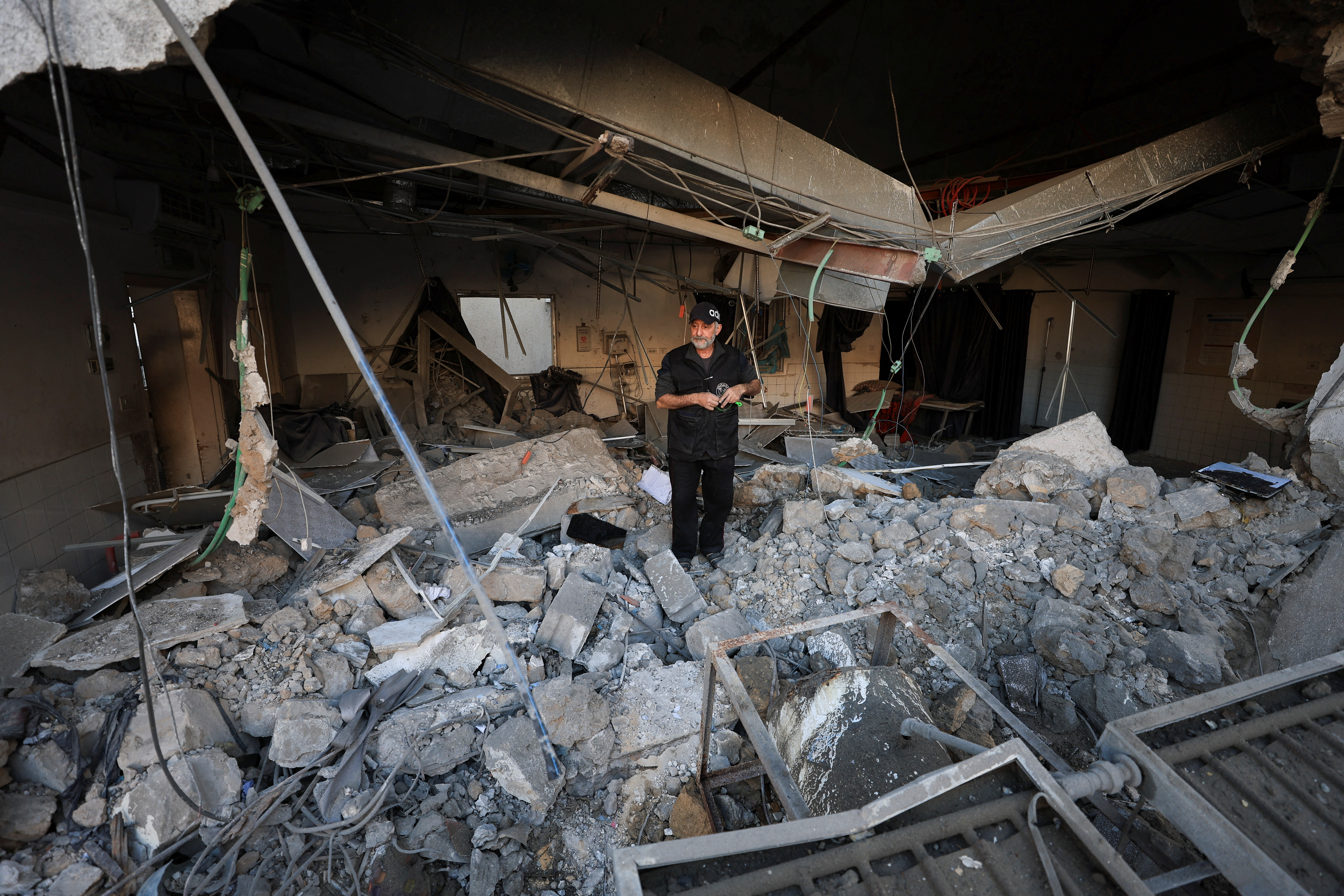 a man stands inside the ruins of a hospital ward