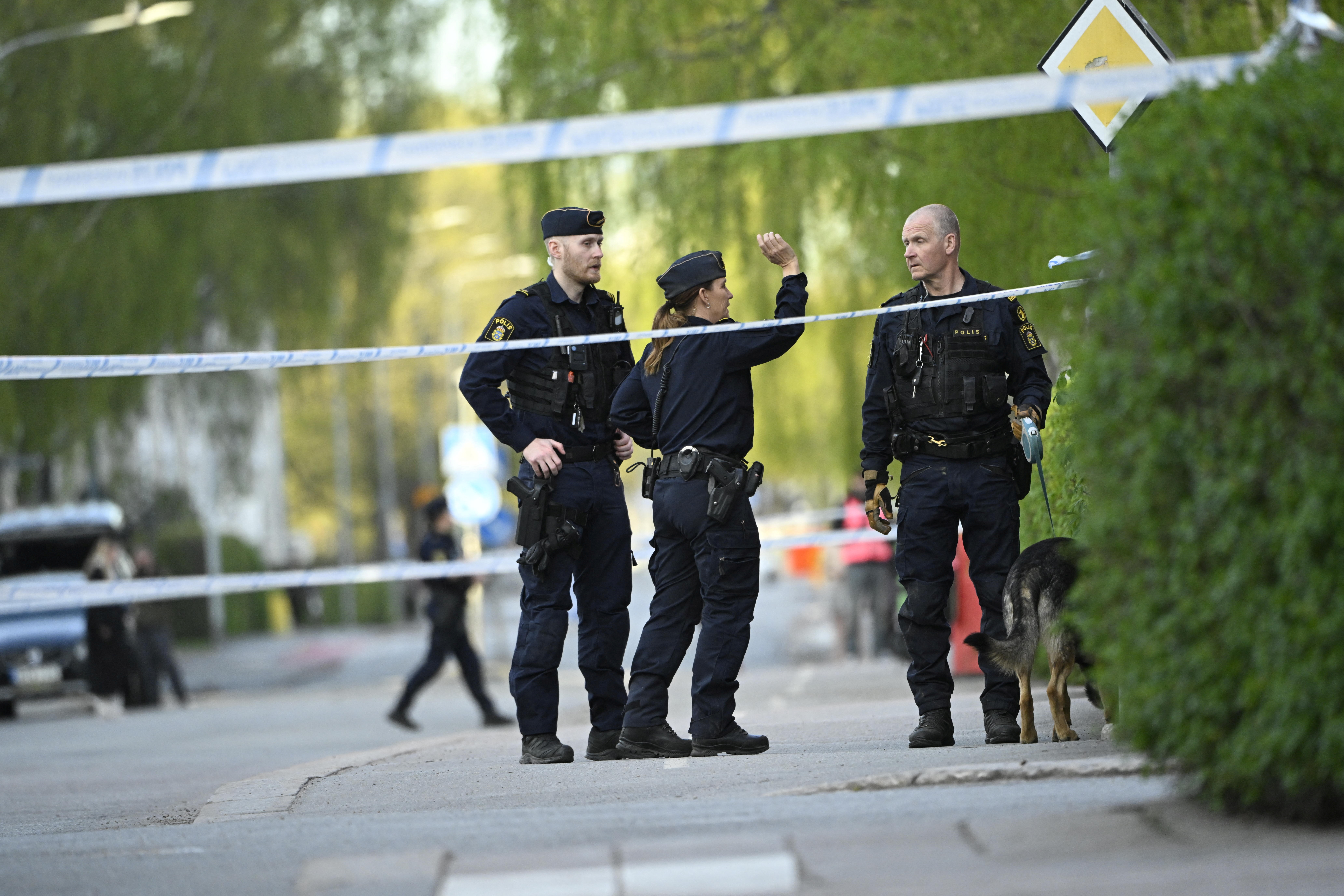 Police officers work near the scene of a deadly shooting in Uppsala
