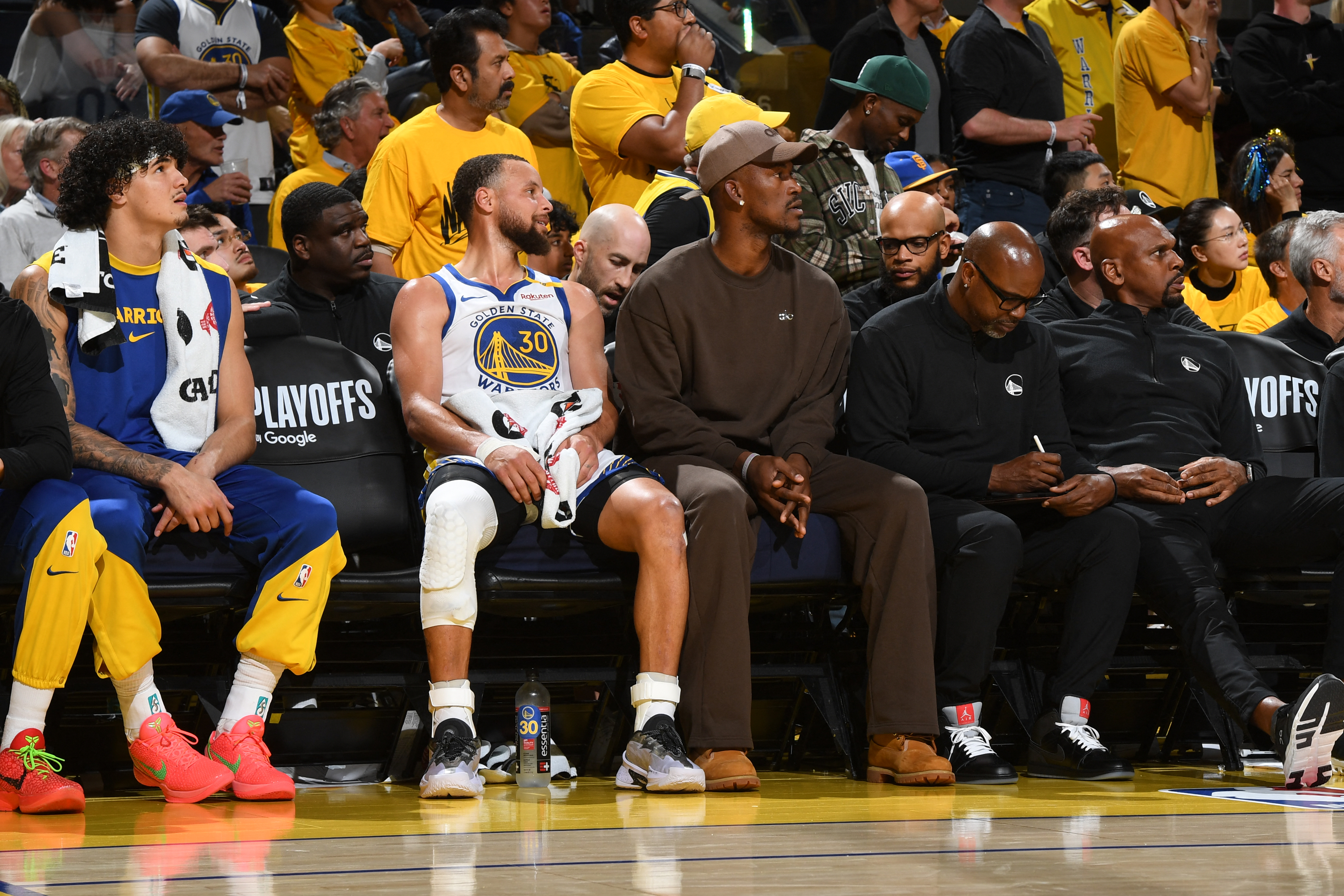 Stephen Curry and the injured Jimmy Butler of the Golden State Warriors look on during Game 3 against the Houston Rockets