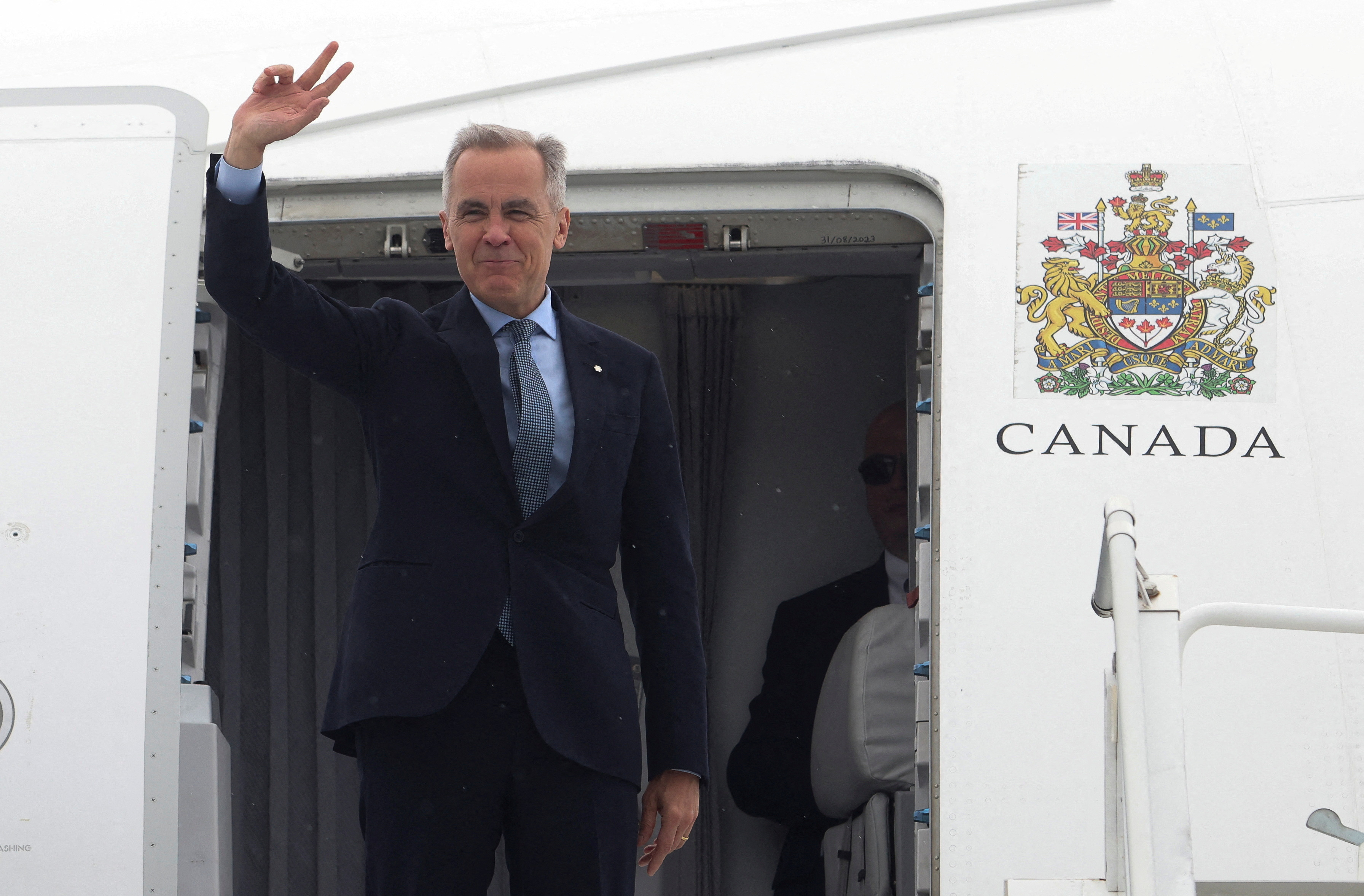 FILE PHOTO: Canada's Prime Minister Mark Carney waves as he boards his plane for Washington, D.C., in Ottawa, Ontario, Canada, May 5, 2025. REUTERS/Patrick Doyle/File Photo