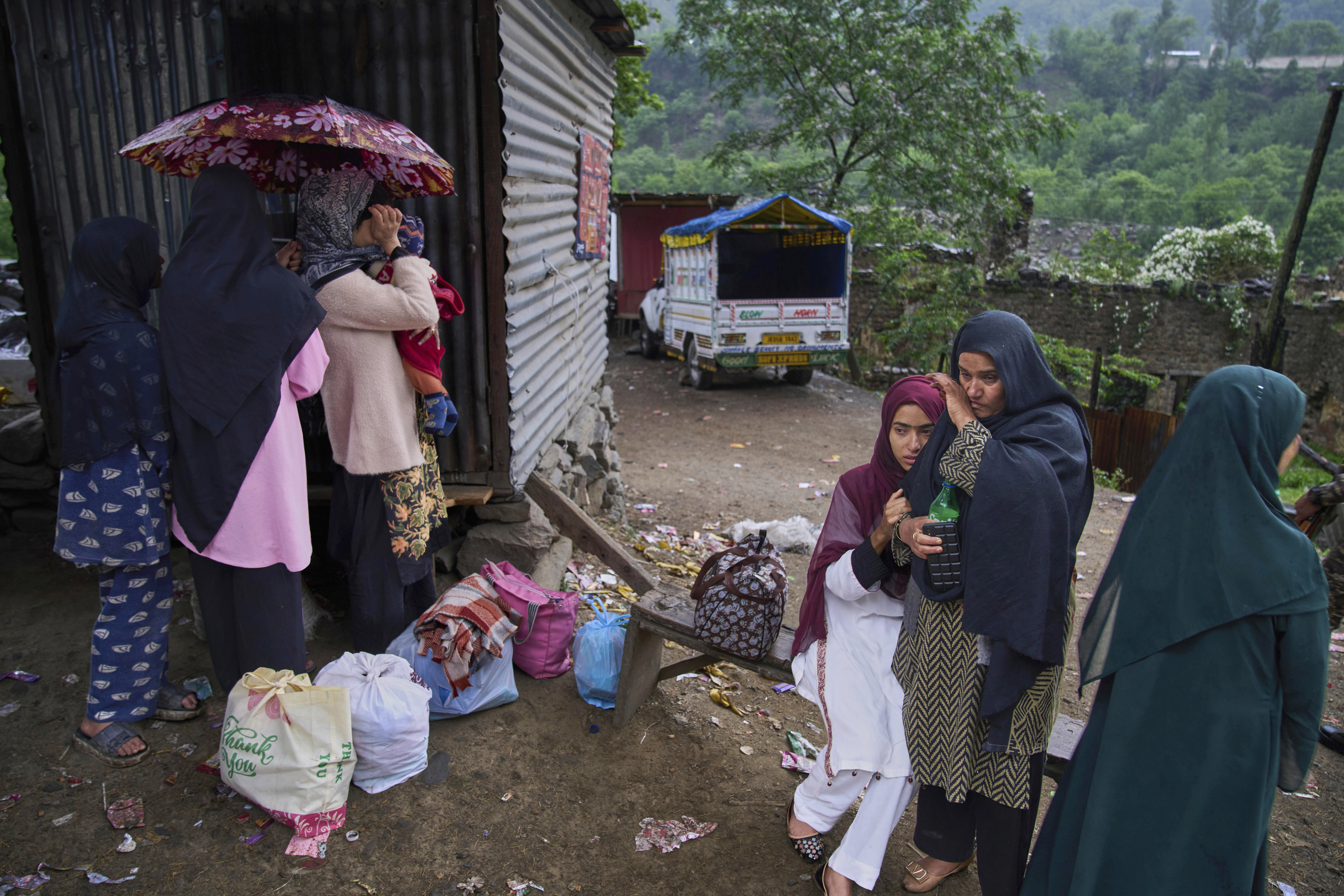 A group of Kashmiri villager women wait for transportation as they leave following overnight shelling from Pakistan at Gingal village in Uri district, Indian controlled Kashmir, Friday, May 9, 2025. (AP Photo/Dar Yasin)
