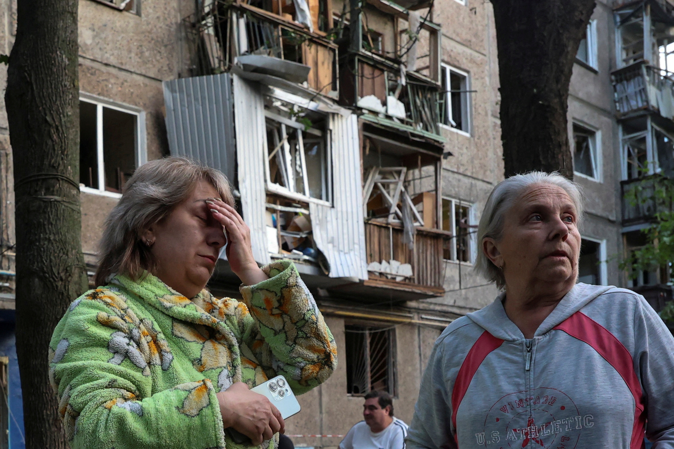 Women react next to their apartment building damaged by a Russian drone strike, amid Russia's attack on Ukraine, in Kharkiv, Ukraine June 11, 2025. REUTERS/Vyacheslav Madiyevskyy TPX IMAGES OF THE DAY