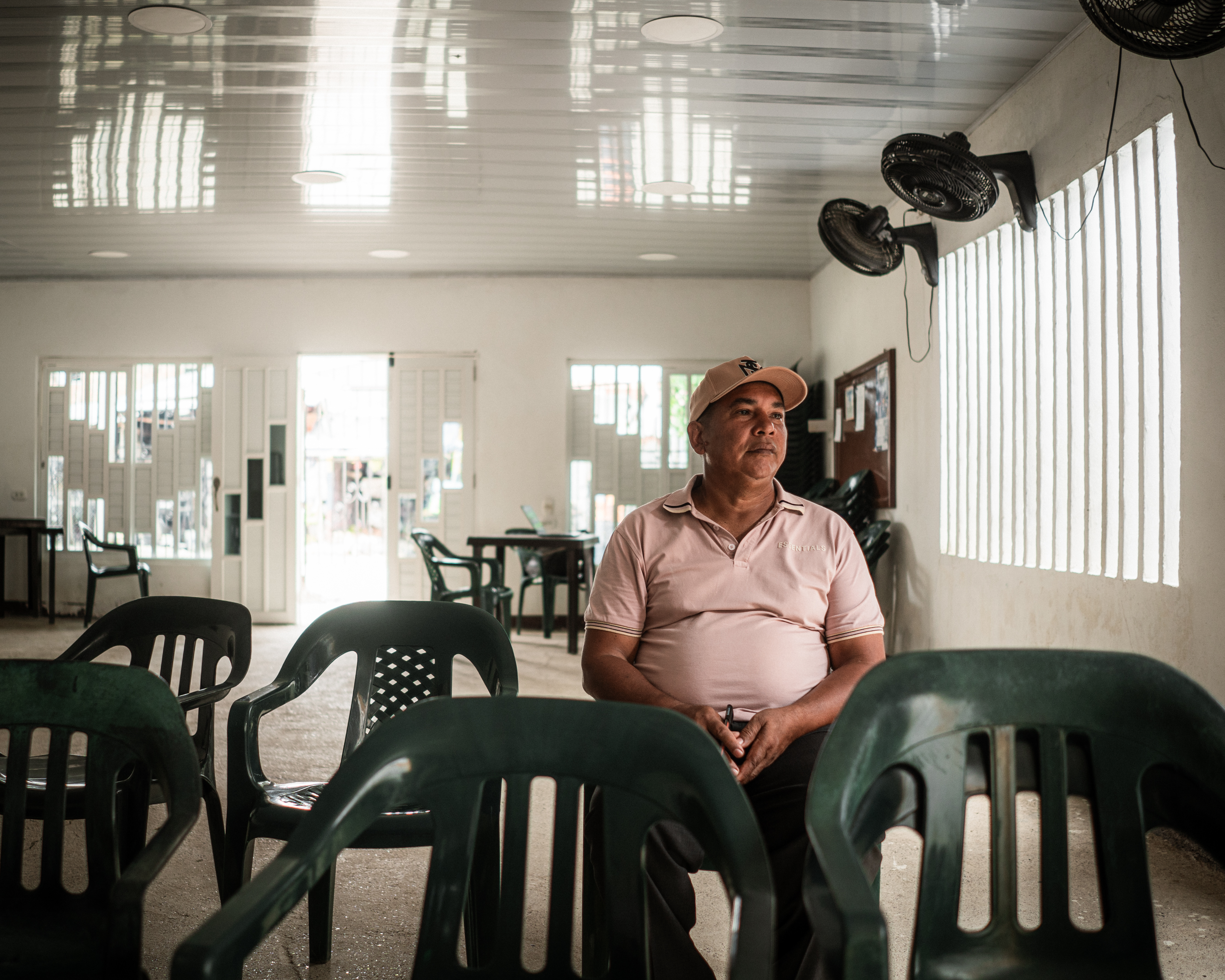 Pastor Jose Luís Ballesta Mendoza seated in a row of plastic chairs