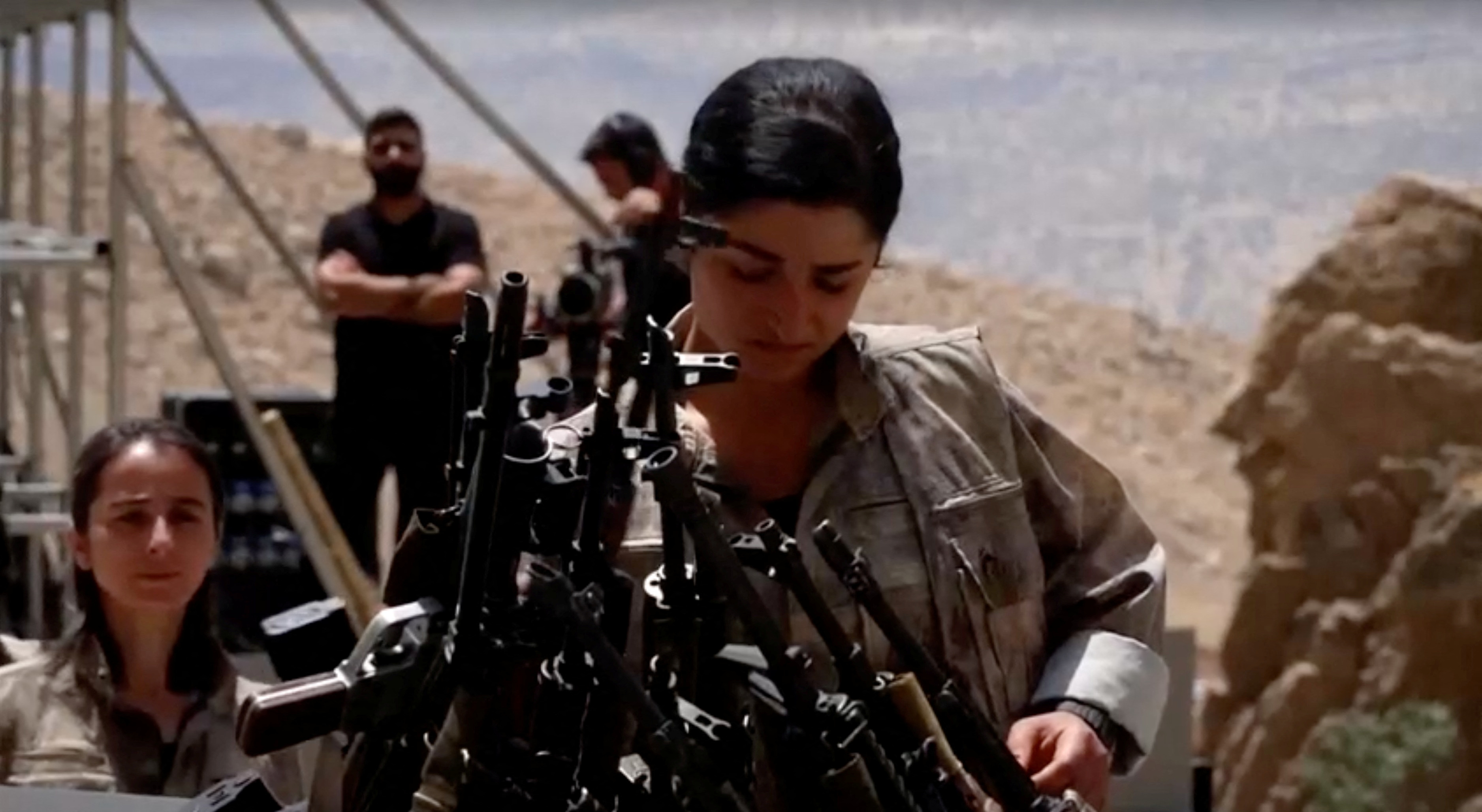 An armed PKK fighter places a weapon to be burnt during a disarming ceremony in Sulaimaniya, Iraq