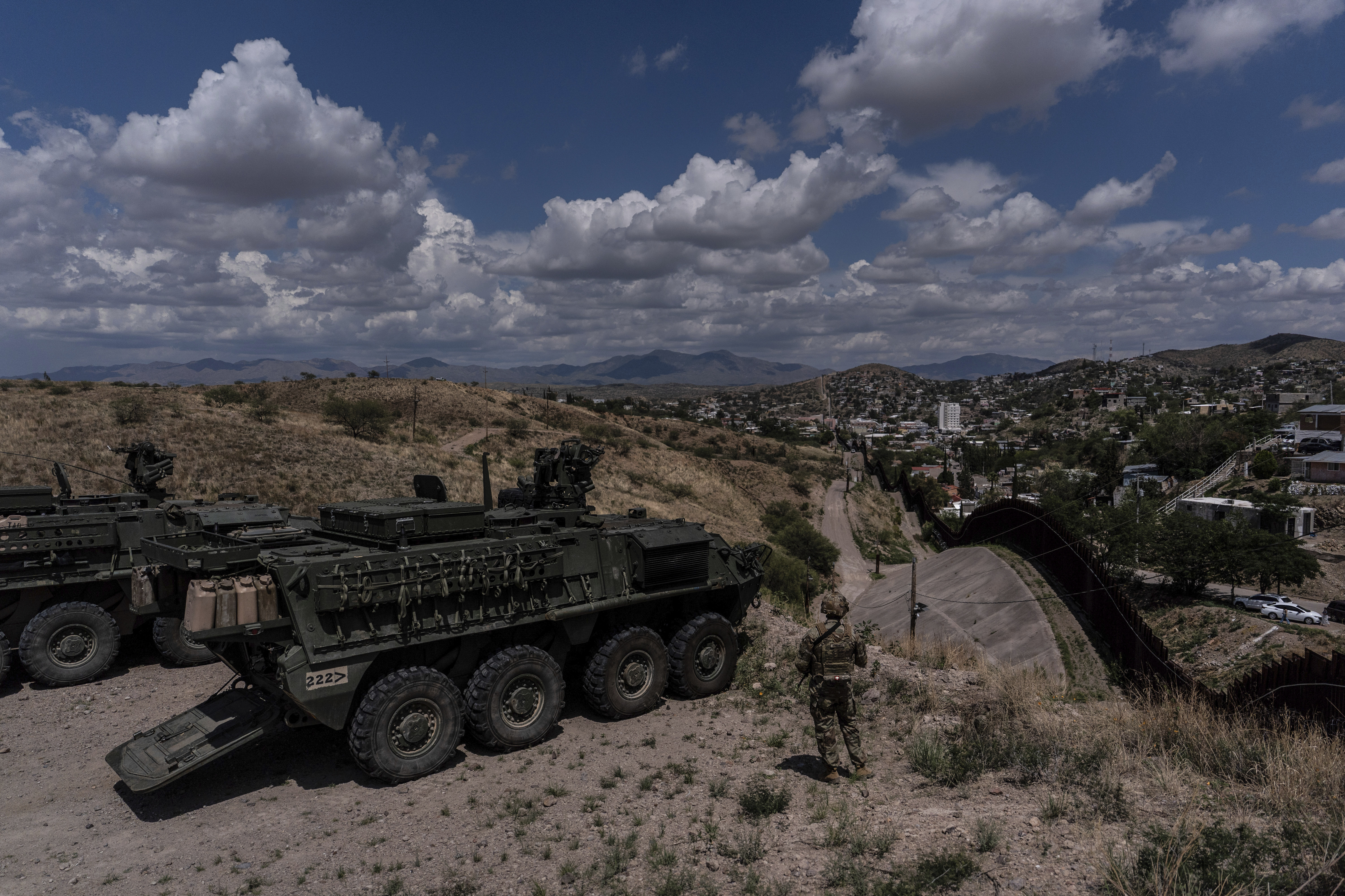 U.S. Army Sgt. Salvador Hernandez stands beside Stryker combat vehicles while watching over the U.S.-Mexico border fence from a hilltop in Nogales, Ariz., Tuesday, July 22, 2025. (AP Photo/Jae C. Hong)