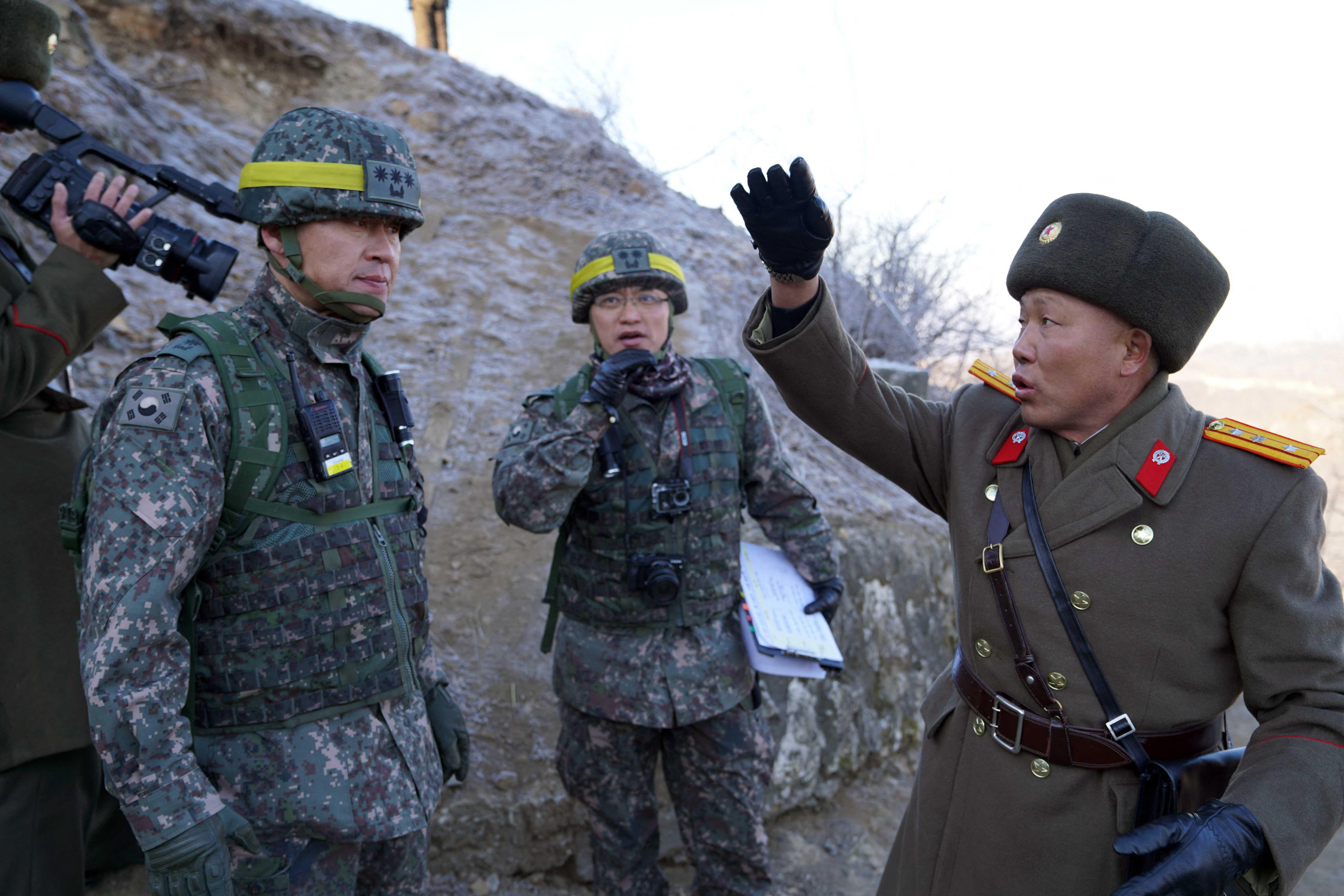 This handout photo taken on December 12, 2018 and provided by South Korean Defence Ministry shows a North Korean soldier (R) speaking with South Korean soldiers during an inspection of the dismantled North Korean guard post inside the Demilitarized zone (DMZ) dividing the two Koreas in Cheorwon. Soldiers from North and South Korea crossed into each other's territory peacefully for the first time on December 12, Seoul said, as they began checking the dismantlement of guard posts in the Demilitarized Zone. (Photo by handout / various sources / AFP) / RESTRICTED TO EDITORIAL USE - MANDATORY CREDIT "AFP PHOTO / SOUTH KOREAN DEFENCE MINISTRY" - NO MARKETING NO ADVERTISING CAMPAIGNS - DISTRIBUTED AS A SERVICE TO CLIENTS