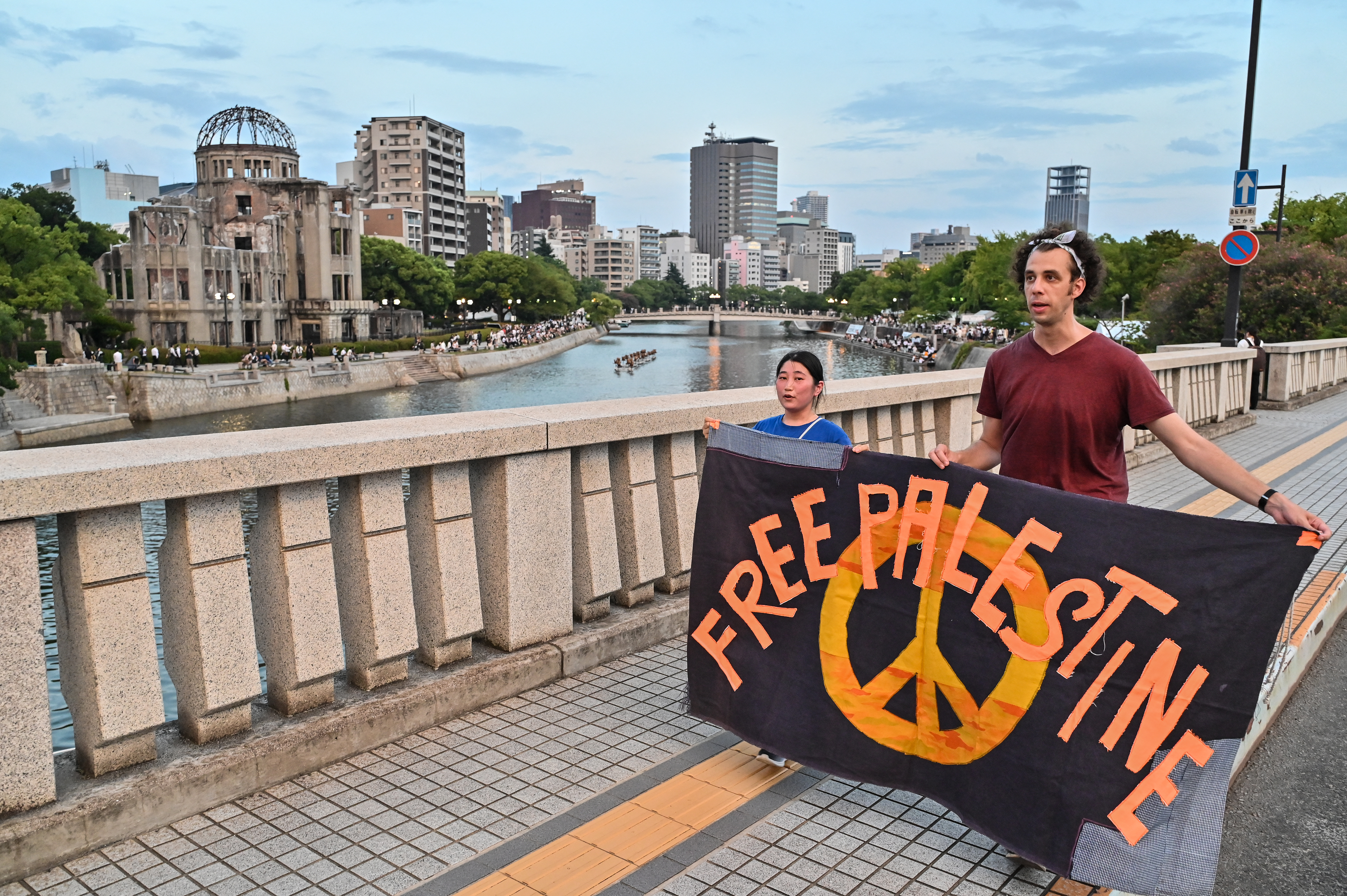 A pair of protesters march with a ‘Free Palestine’ banner past the Atomic Bomb Dome on the eve of the 80th anniversary of the US attack on Hiroshima on August 5