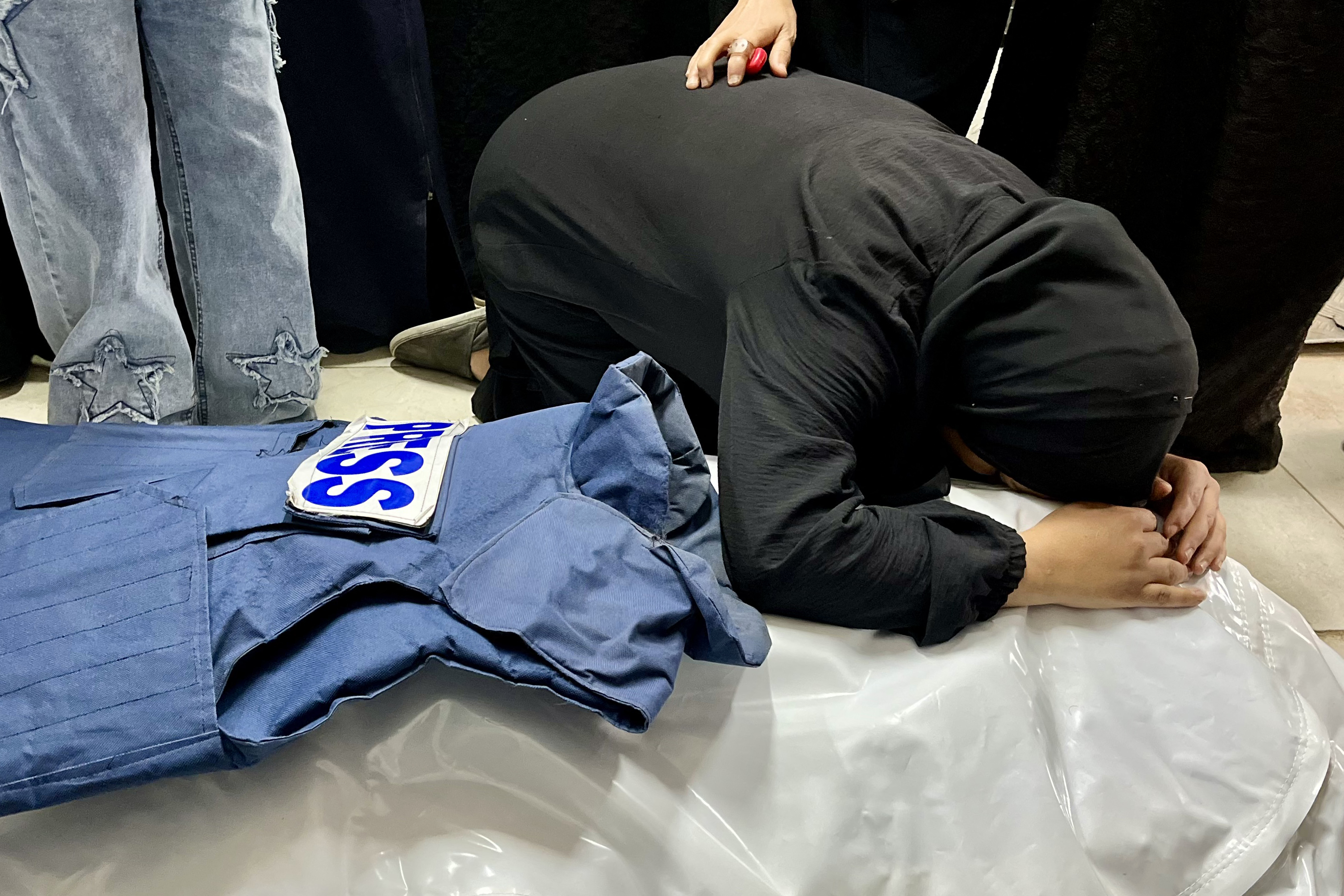A woman mourns over the body of journalist Ahmed Mansur at Nasser Medical Complex in Khan Yunis in the southern Gaza Strip on April 8, 2025. [AFP]