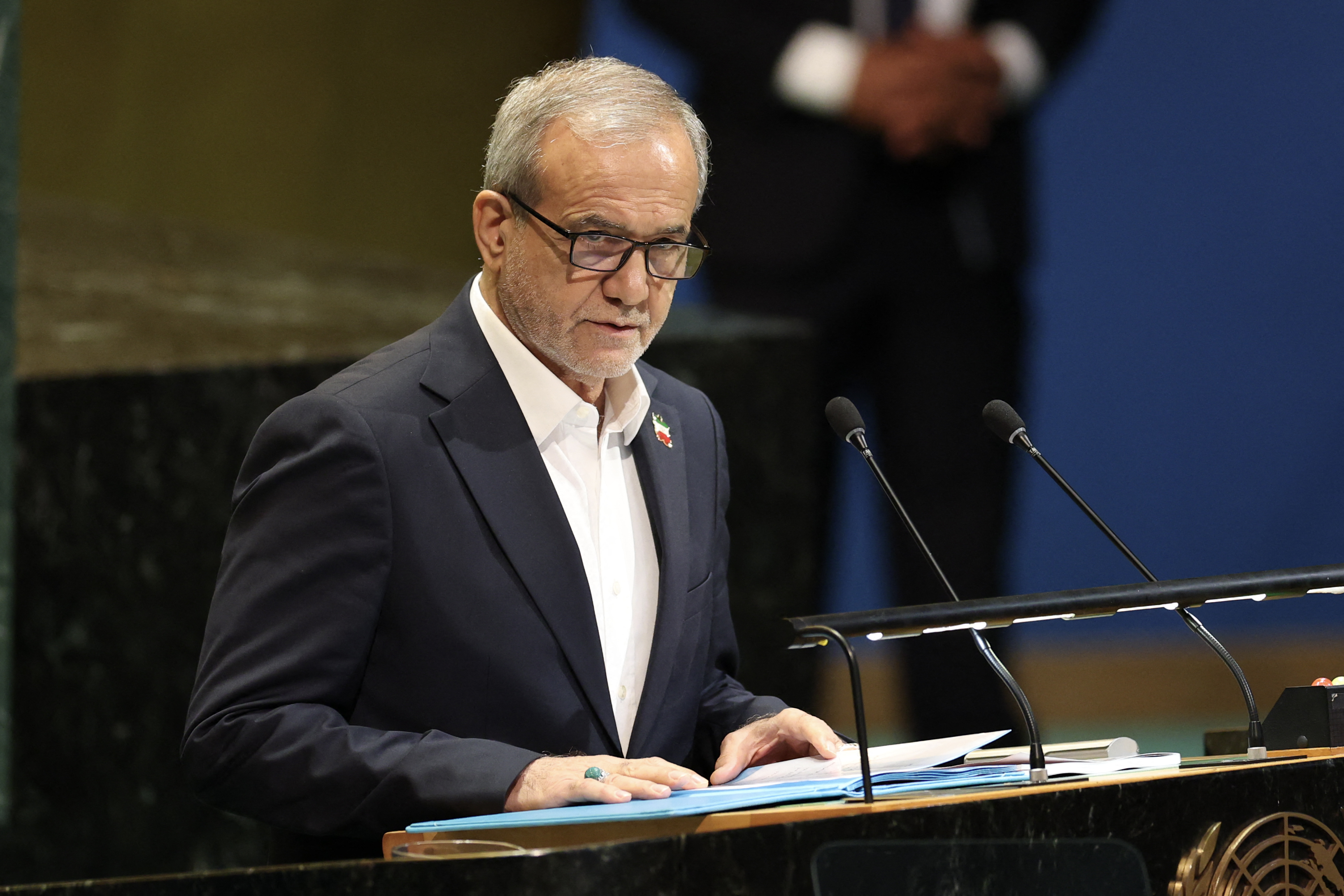 Iran's President Masoud Pezeshkian speaks at a podium.