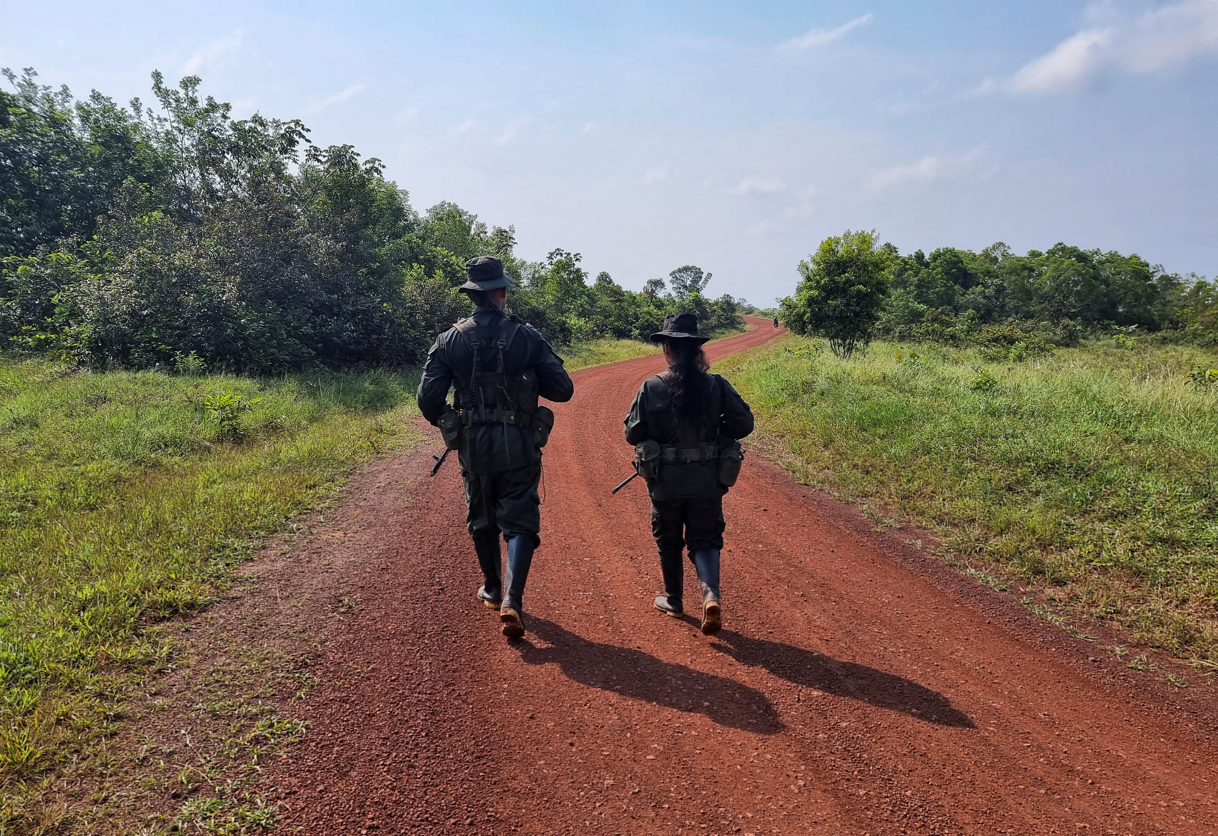 Guerrillas from the EMC walk down a dirt road in Colombia