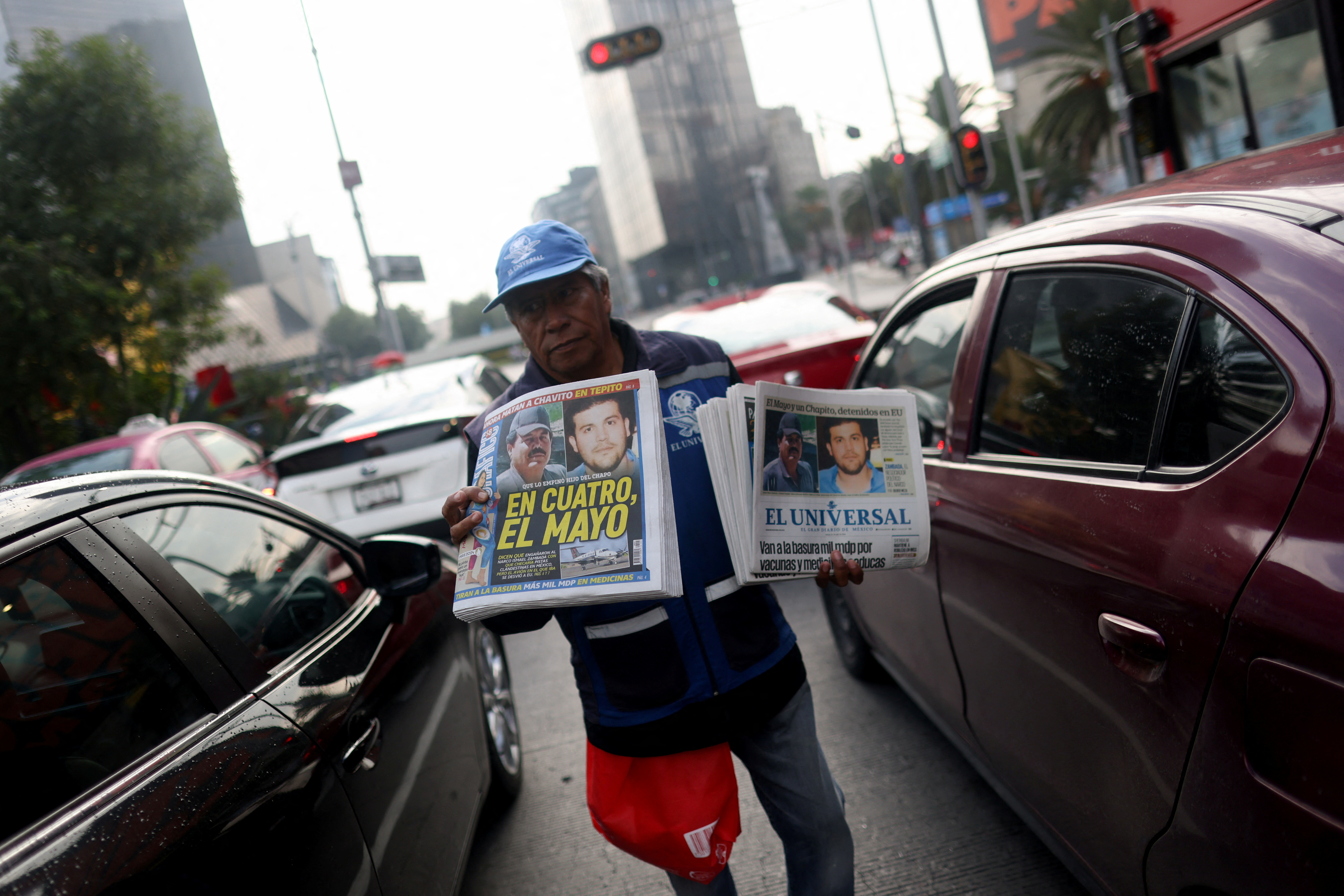 A newspaper vendor walks through traffic selling newspapers reporting the El Paso, Texas, U.S., arrest of Mexican drug lord Ismael "El Mayo" Zambada and Joaquin Guzman Lopez, "El Chapo" Guzman’s son, in Mexico City, Mexico July 26, 2024. REUTERS/Gustavo Graf