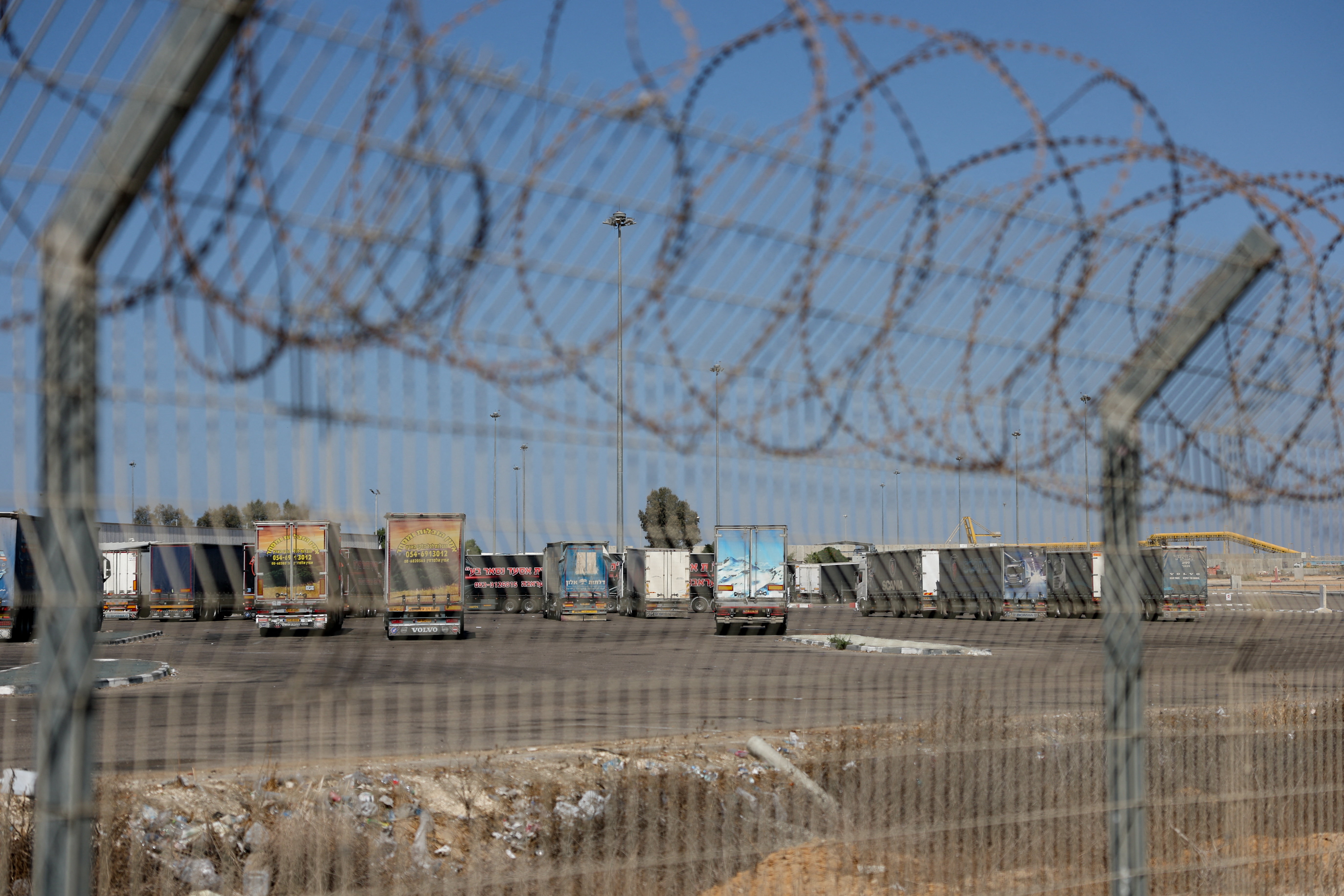 Trucks carrying aid wait at the Israeli side of the Kerem Shalom border crossing to southern Gaza, amid a ceasefire deal between Israel and Hamas, in southern Israel, October 20, 2025. REUTERS/Hannah McKay