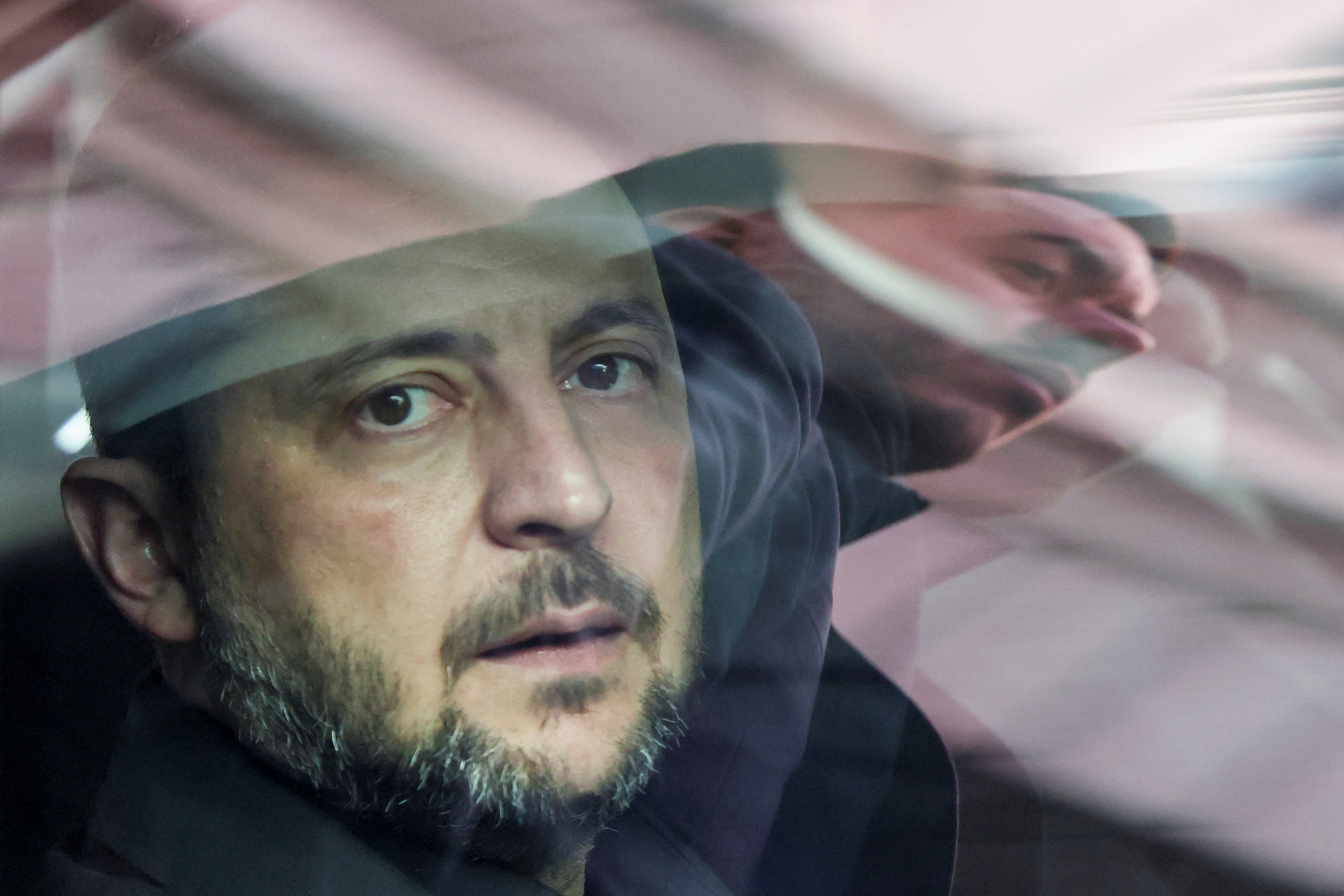 A security member is reflected in the window of Ukrainian President Volodymyr Zelenskyy's car [File: Susana Vera/Reuters]