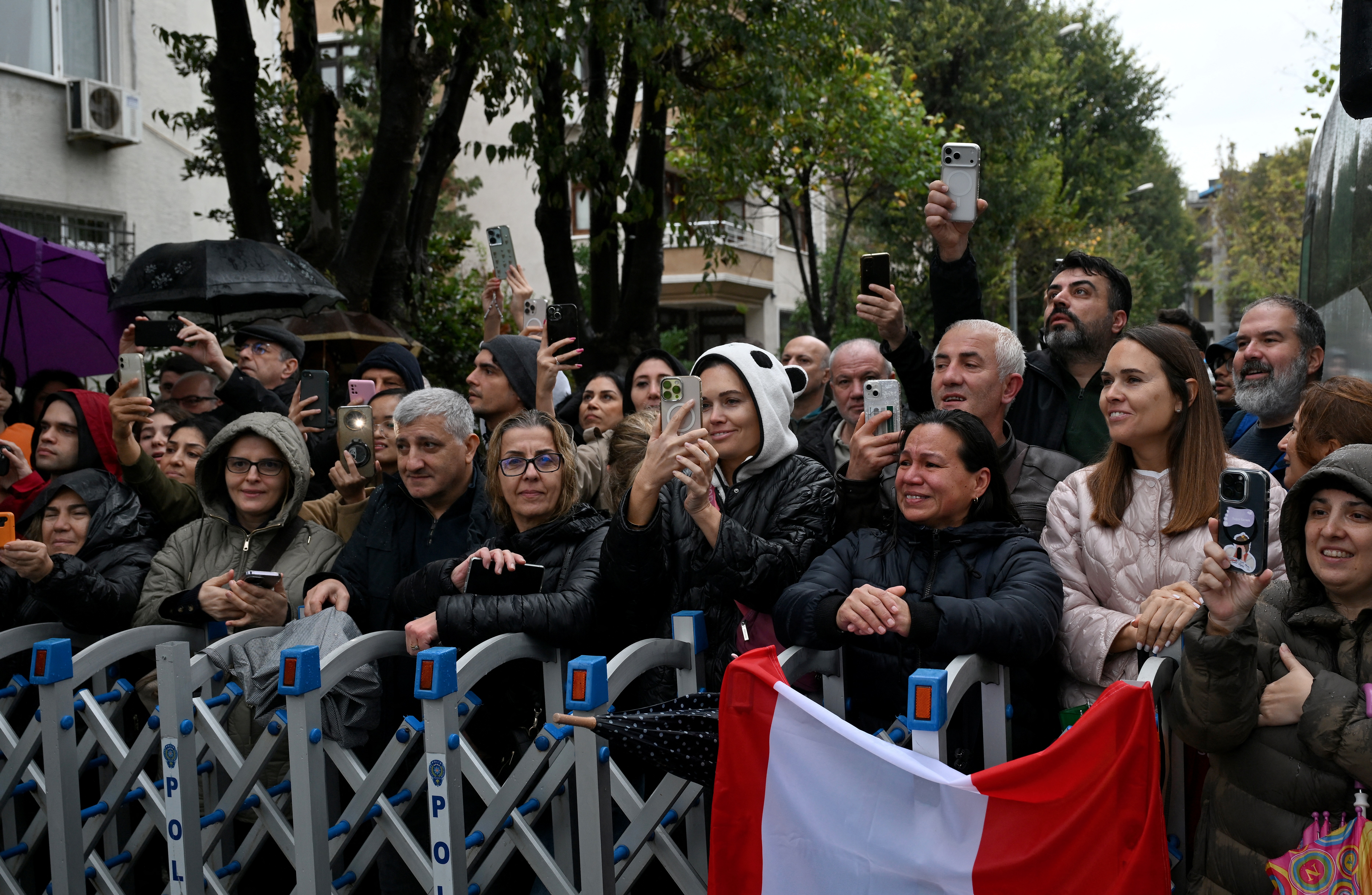 People react and take photos in front of the Mor Ephrem Syriac Orthodox Church, where Pope Leo XIV meets with religious leaders, in Istanbul on November 29, 2025