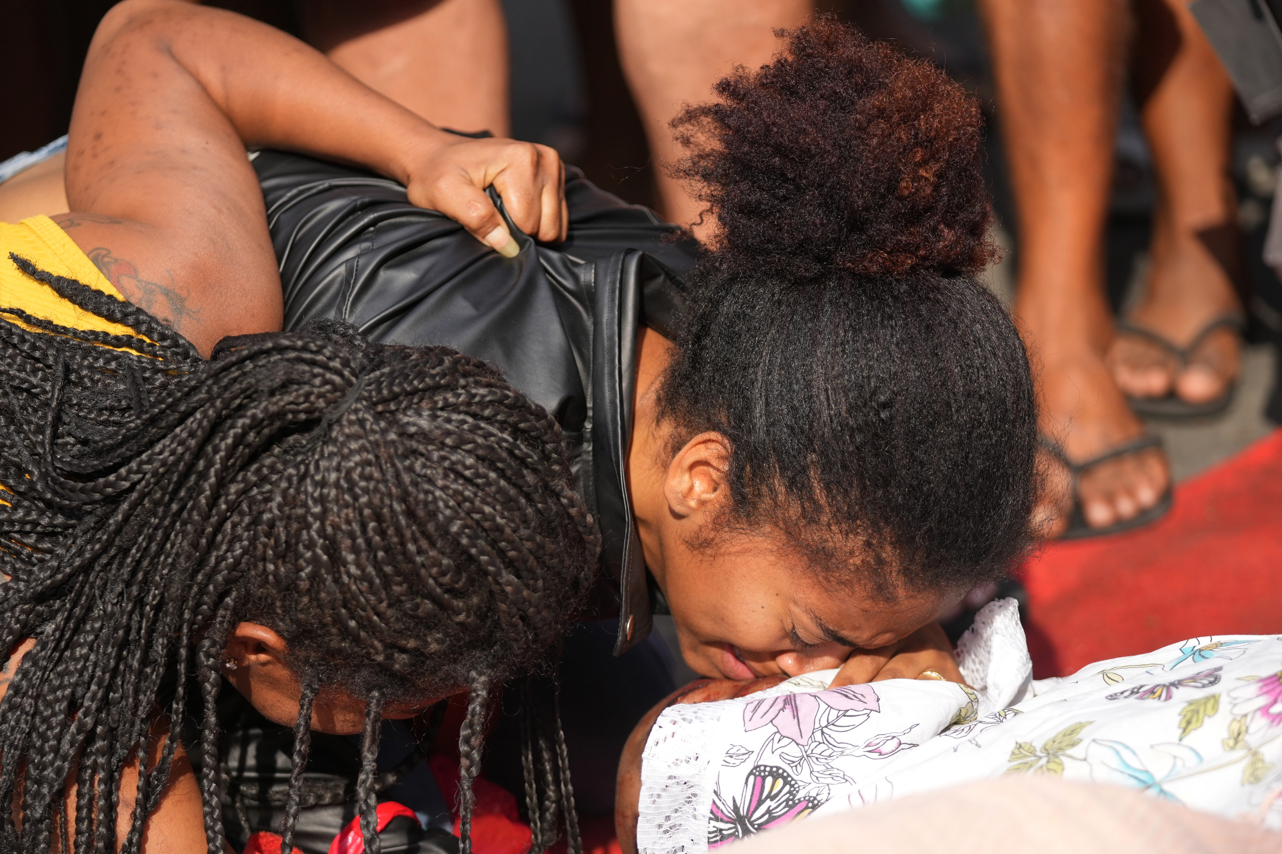 Relatives mourn beside the bodies of people killed the day before during a police raid targeting the Comando Vermelho gang in the Complexo da Penha favela of Rio de Janeiro, Brazil, Wednesday, Oct. 29, 2025. (AP Photo/Silvia Izquierdo)